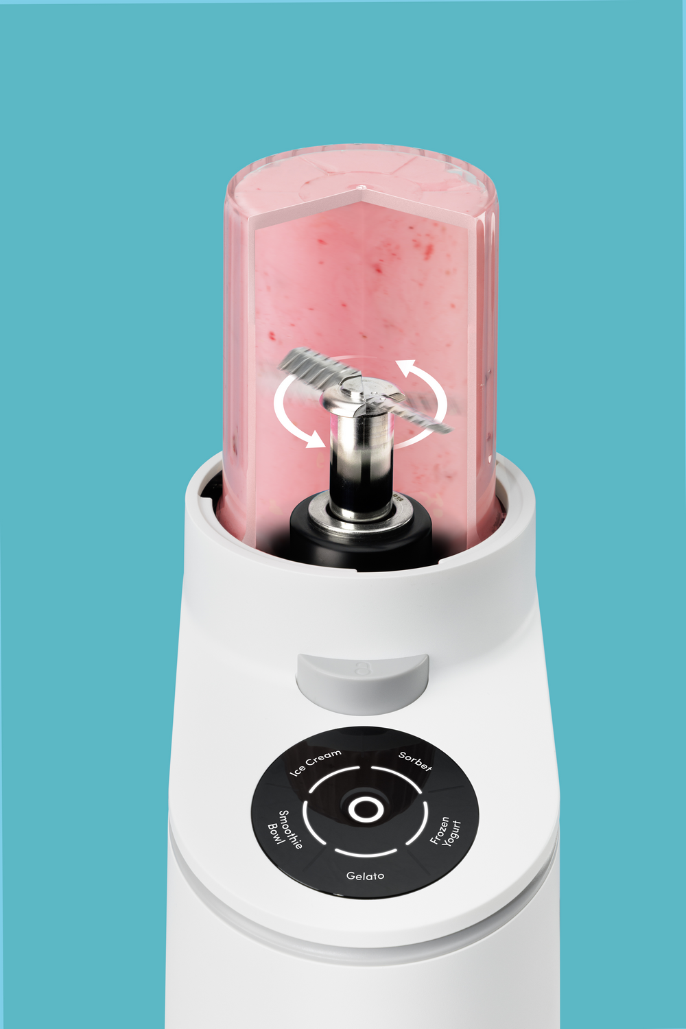 Una batidora blanca con un recipiente transparente lleno de mezcla de frutas rosa y cuchillas giratorias.