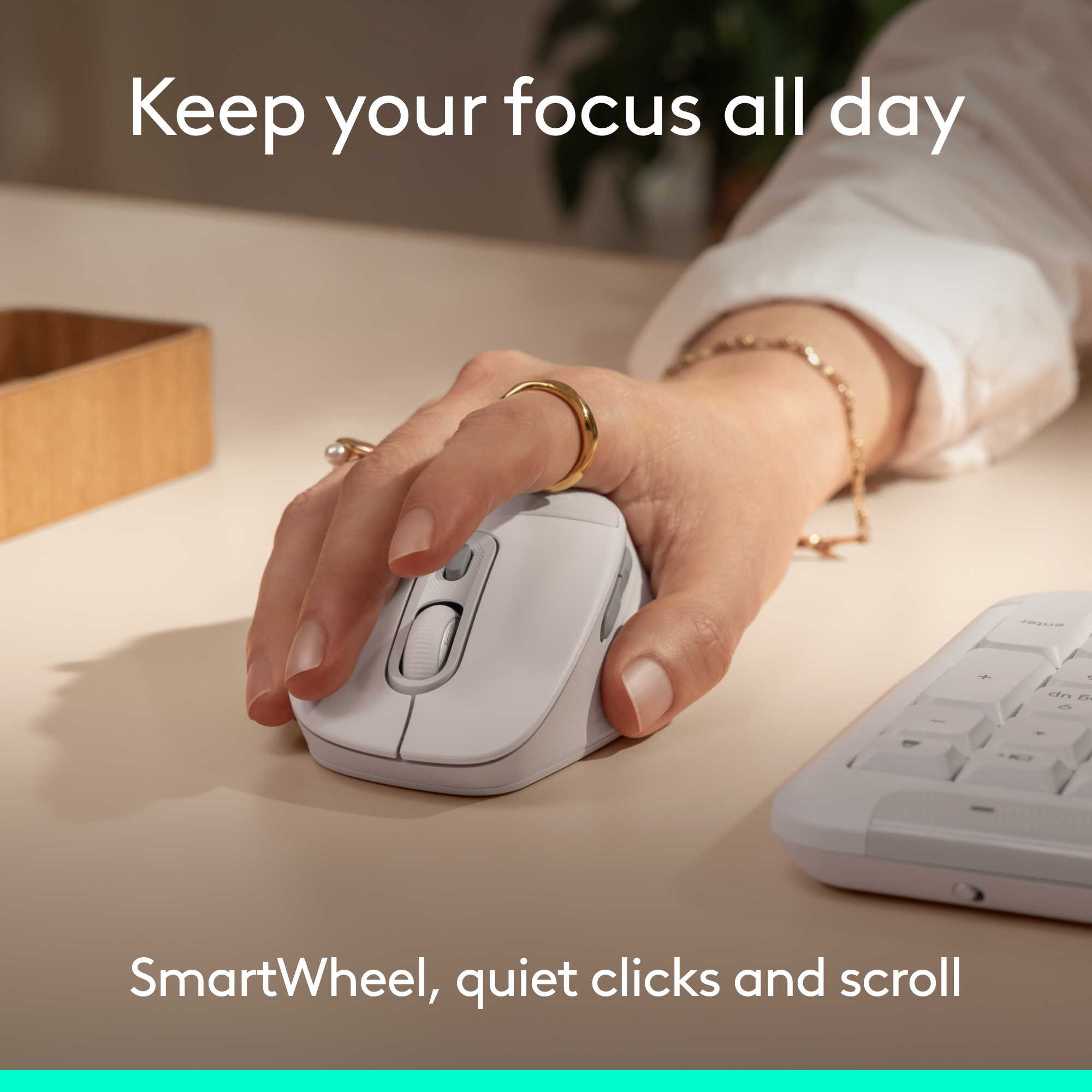 Una mano usa un mouse e una tastiera bianchi su una scrivania.