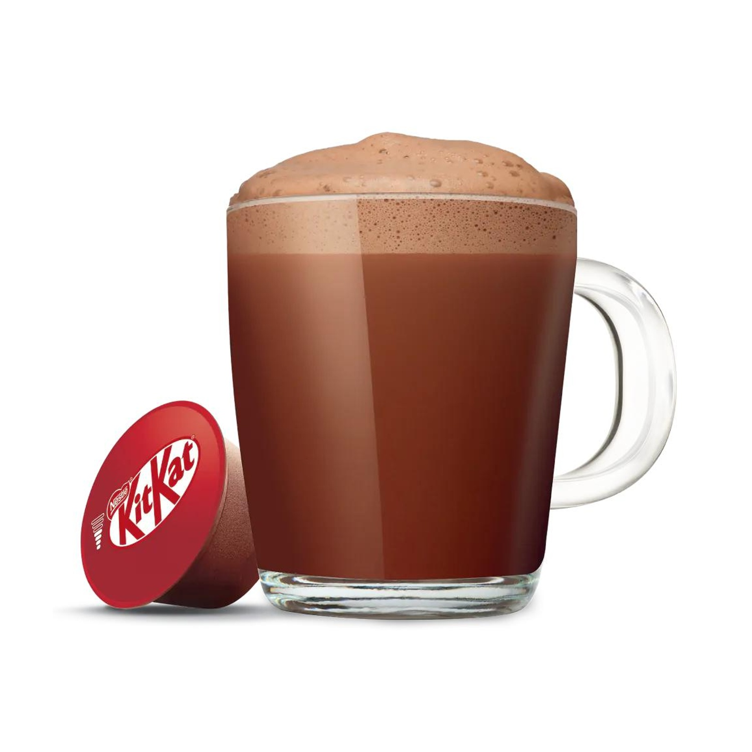 Una tazza di vetro con bevanda al cioccolato schiumosa accanto a una capsula rossa KitKat.