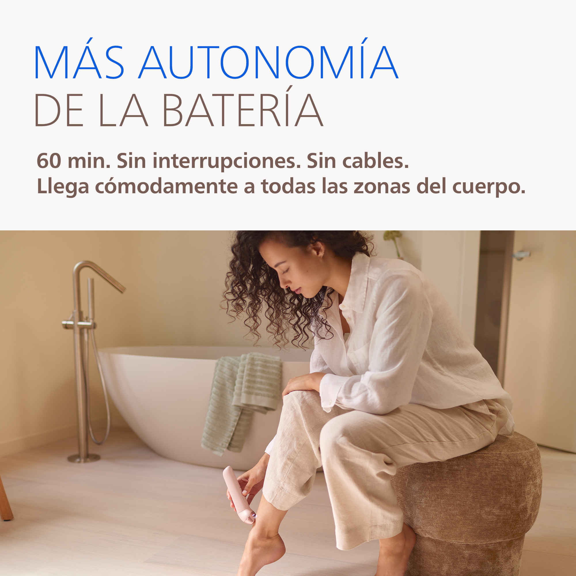 Una mujer usa un depilador en un baño cerca de una bañera.