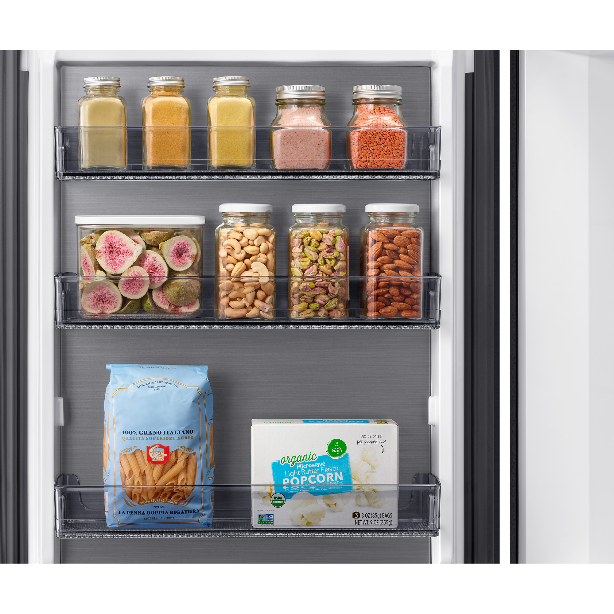 Puerta de refrigerador con frascos de especias, nueces, pasta y palomitas.