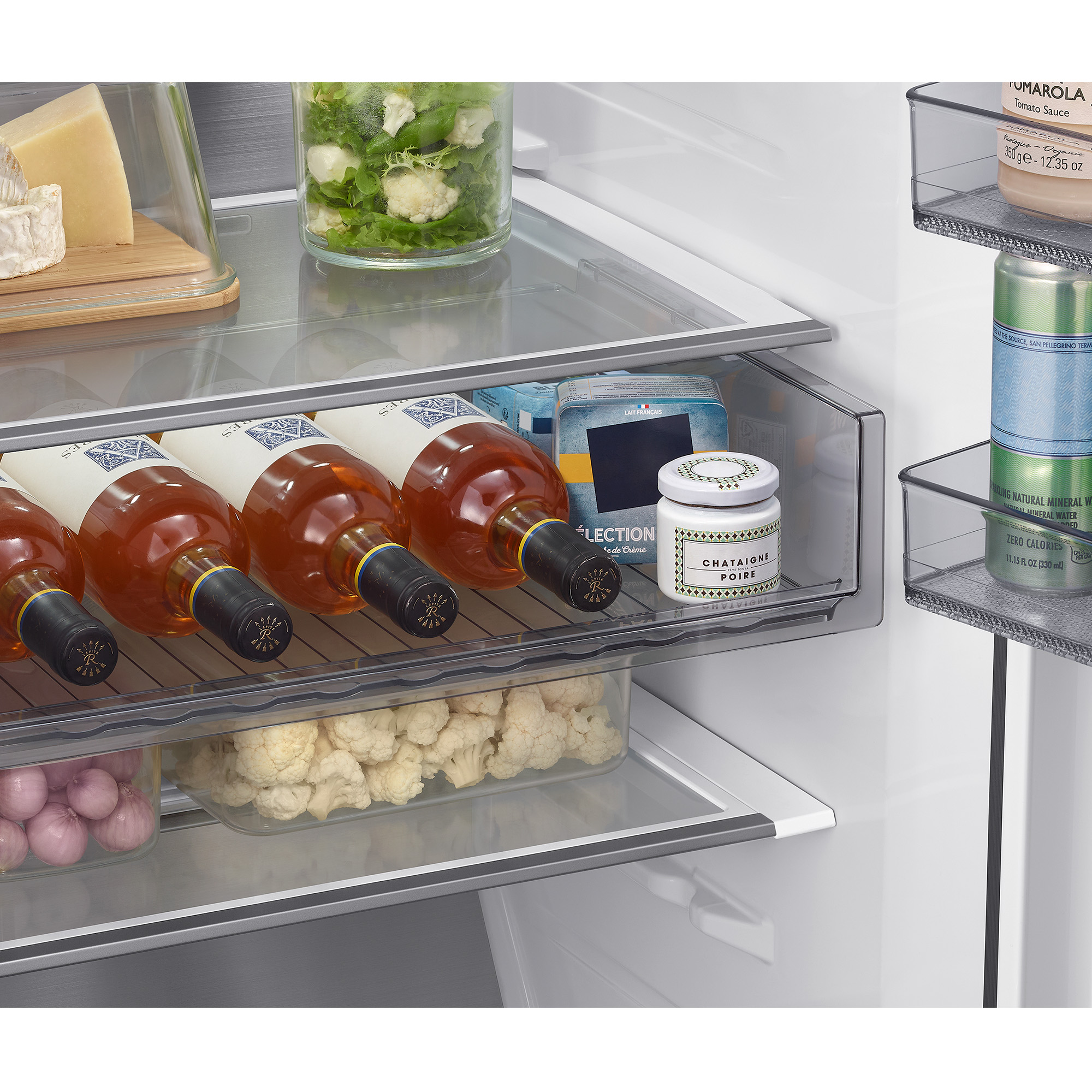 Interior de refrigerador con queso, vino, verduras y bebidas.