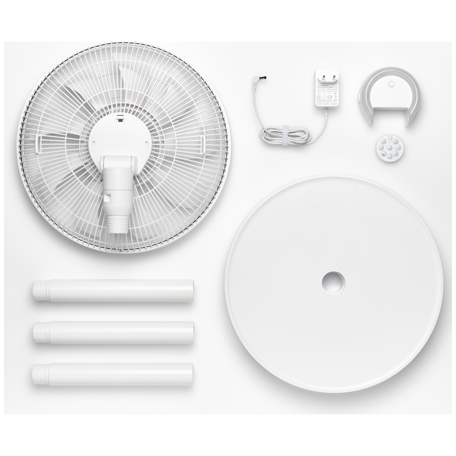 Un ventilateur sur pied blanc est présenté démonté sur fond blanc.