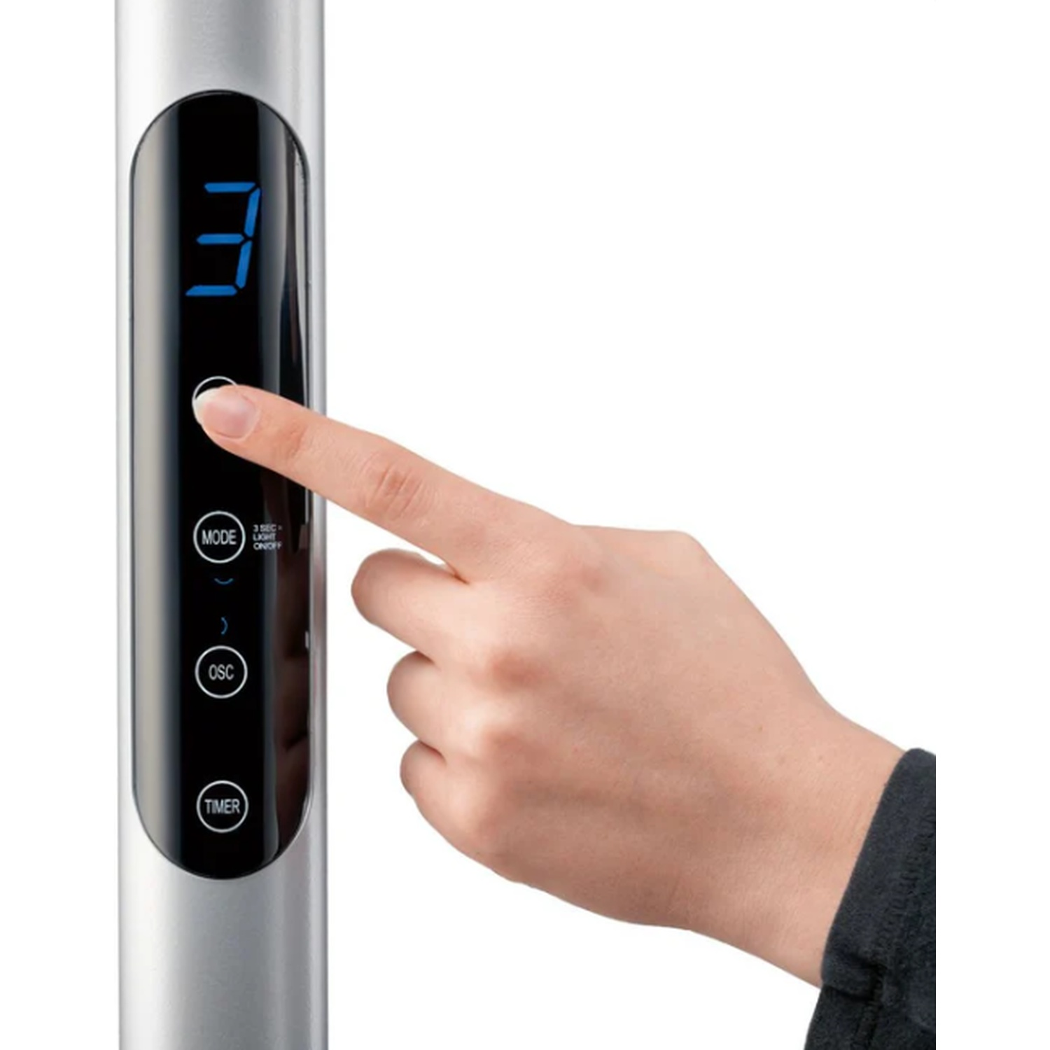 A hand presses a button on a silver device with a digital display.