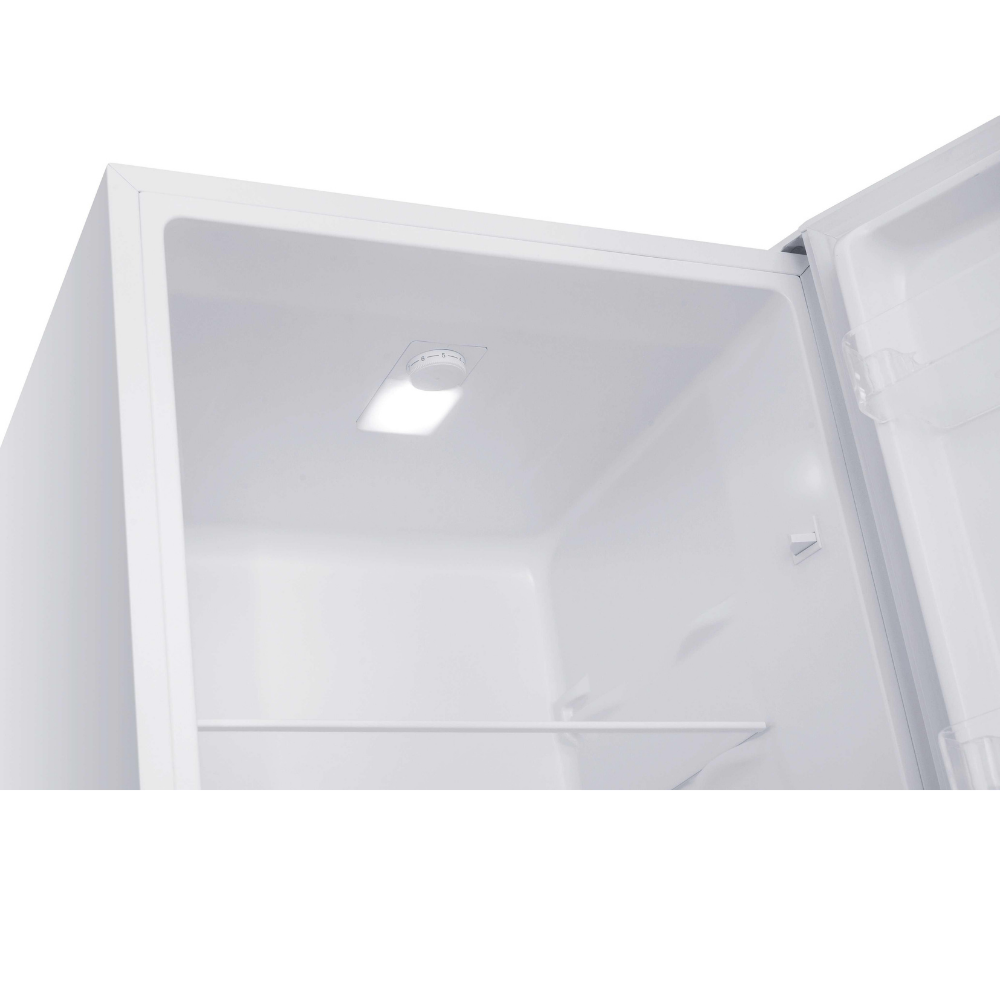 El interior de un refrigerador blanco vacío con luz y un estante.