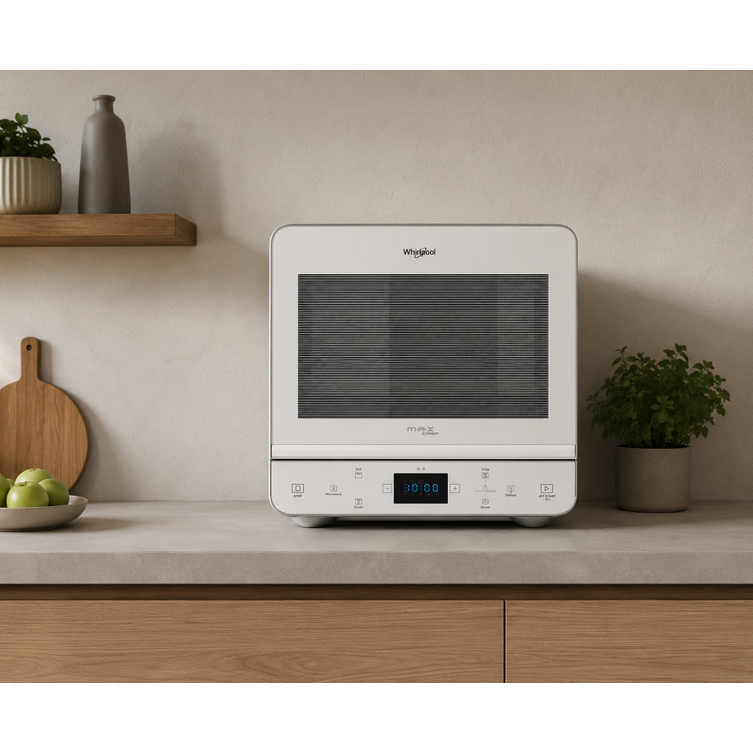 Un forno a microonde bianco Whirlpool MAX si trova su un piano di lavoro in cemento accanto a una pianta verde.