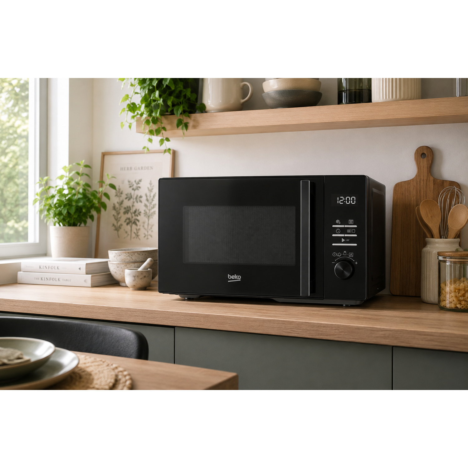 Un microonde Beko nero su un bancone di legno, con oggetti da cucina intorno.