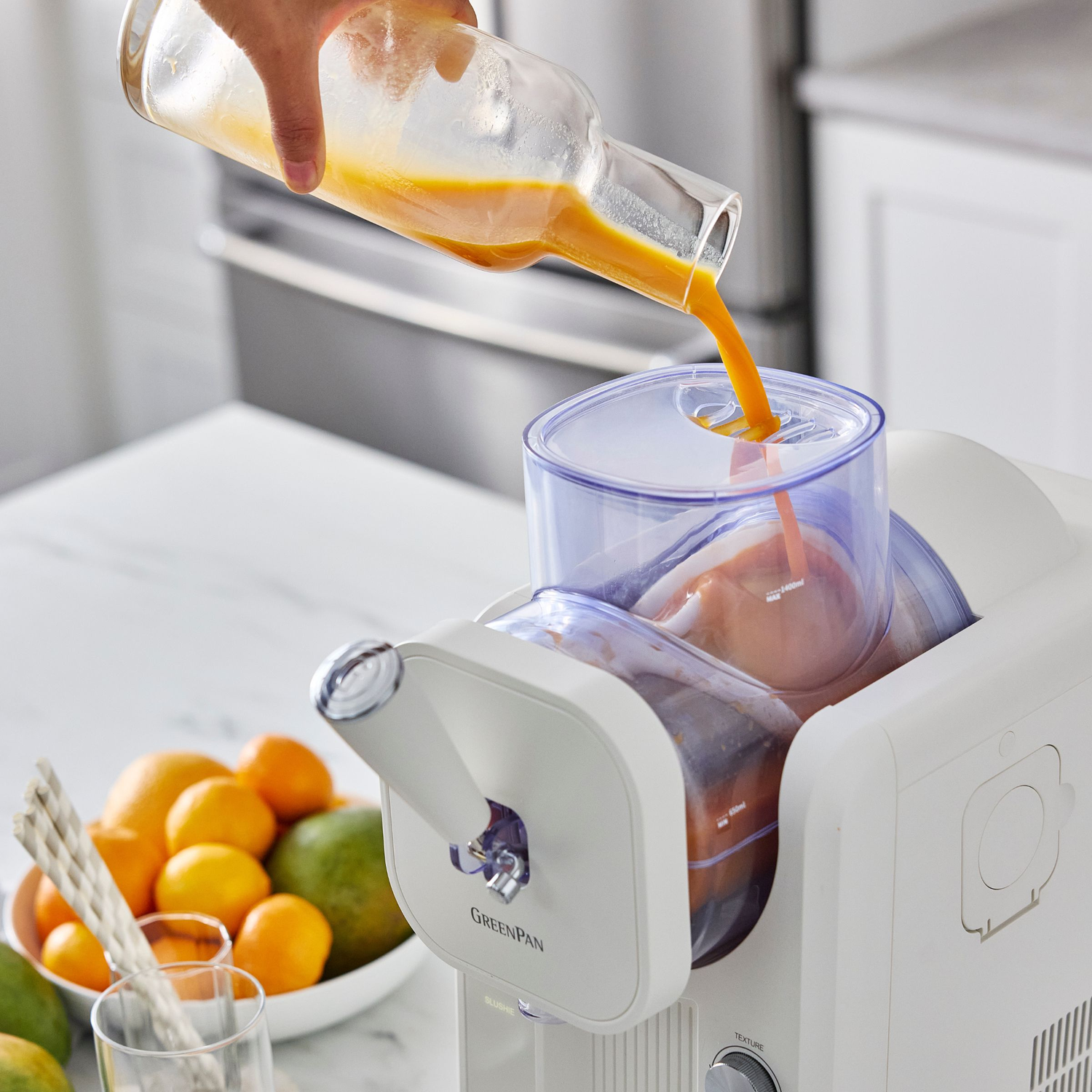 Sinaasappelsap wordt uit een glazen fles in een sapcentrifuge gegoten.