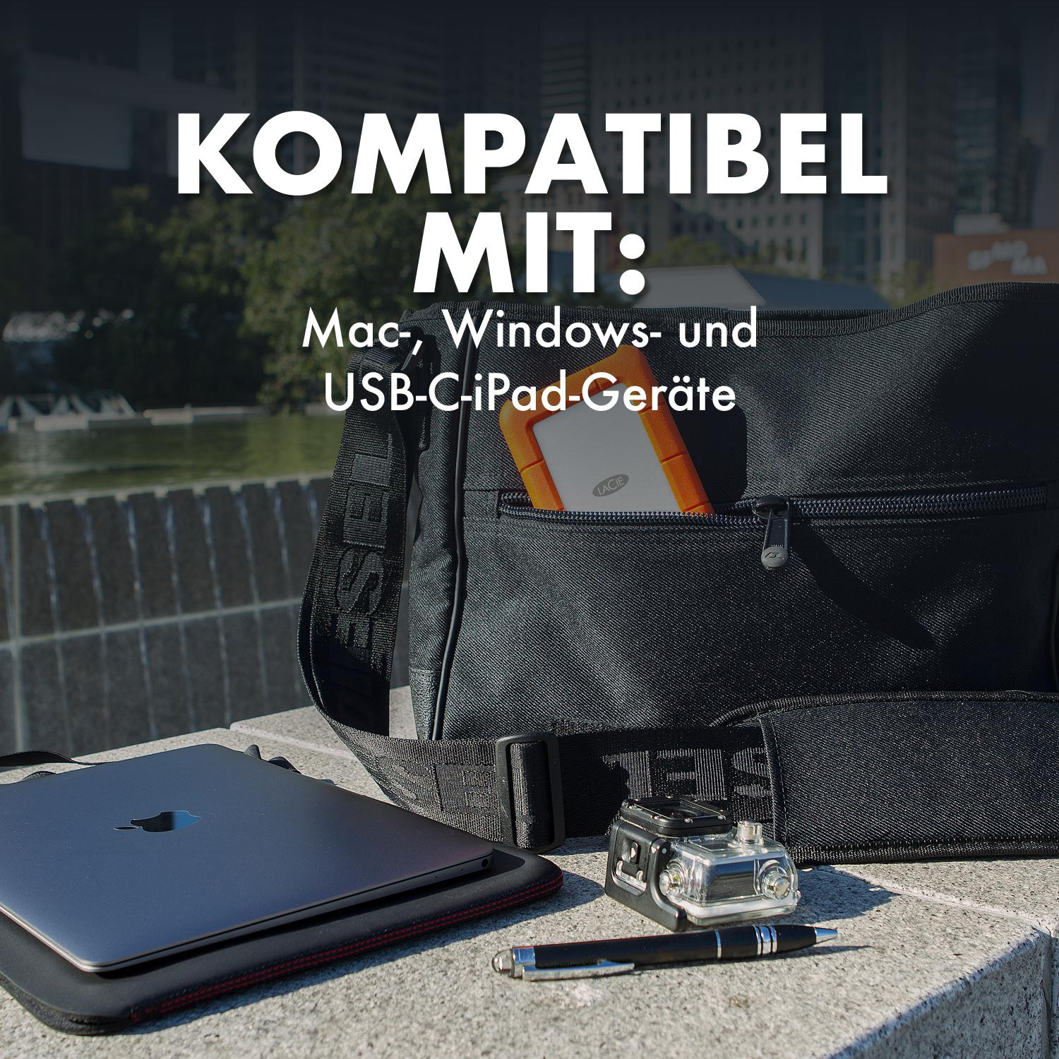 MacBook, externes Laufwerk, GoPro und Stift neben einer Tasche.