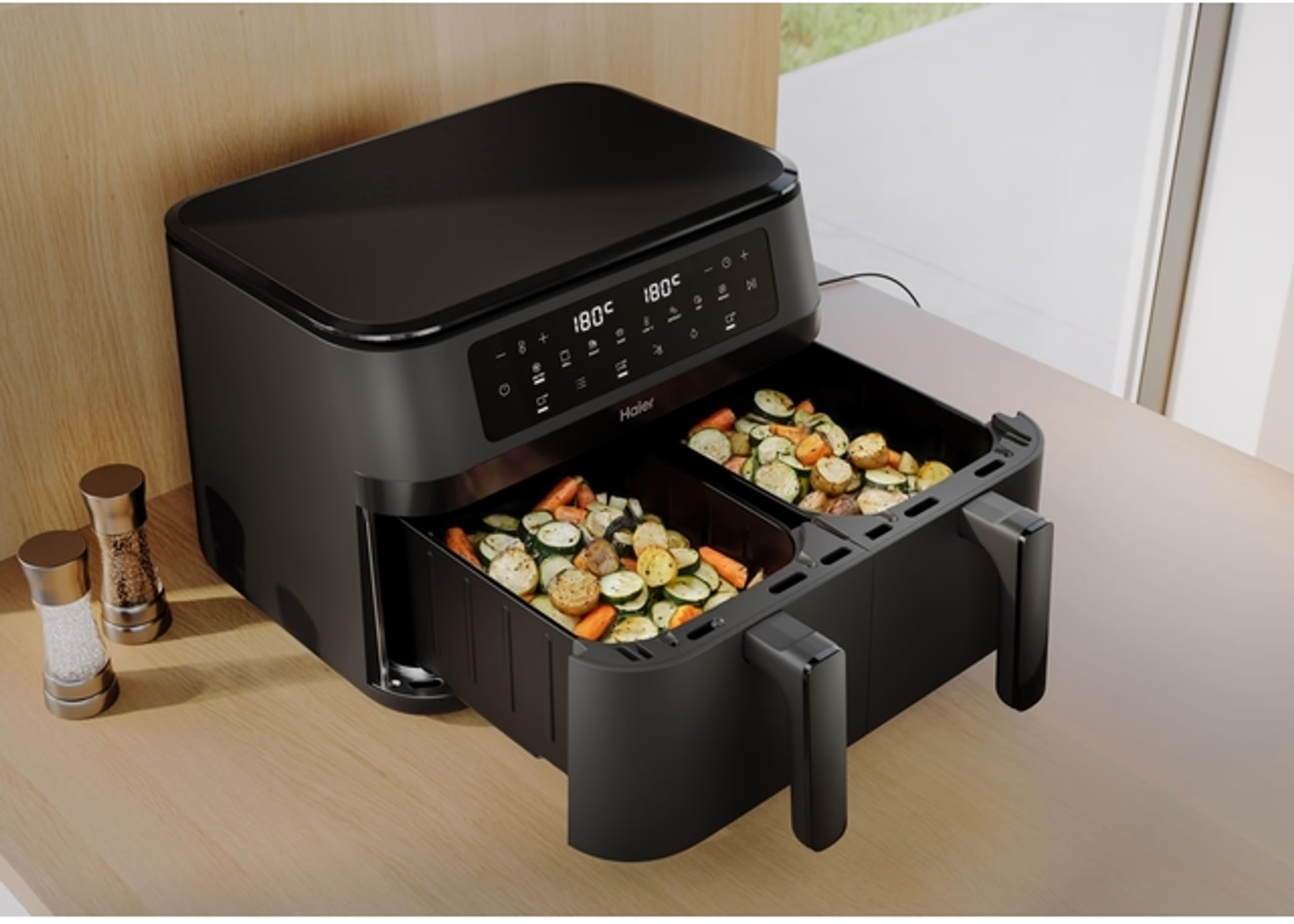 Friggitrice ad aria nera a doppio cassetto con verdure affettate: zucchine e carote.