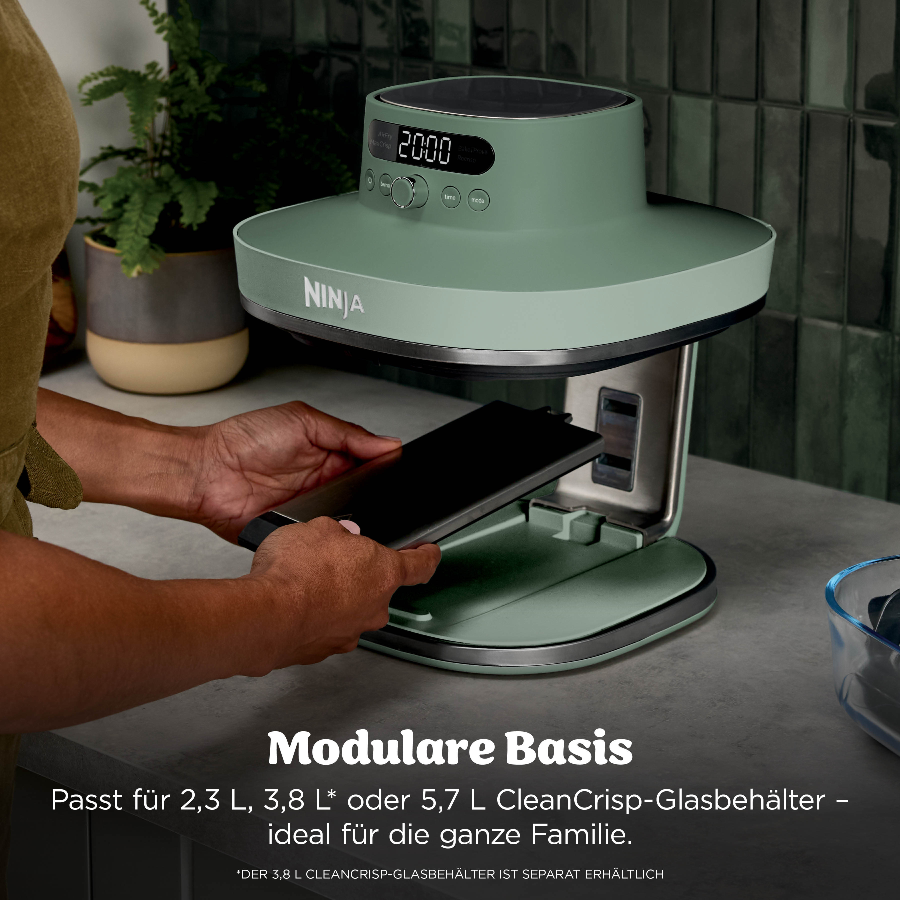 Une personne insère un accessoire noir dans un appareil de cuisine Ninja vert.