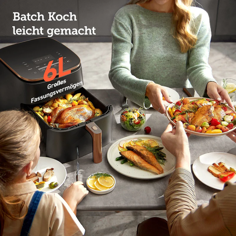 Une friteuse à air avec un poulet rôti et des accompagnements est sur une table où une famille mange.