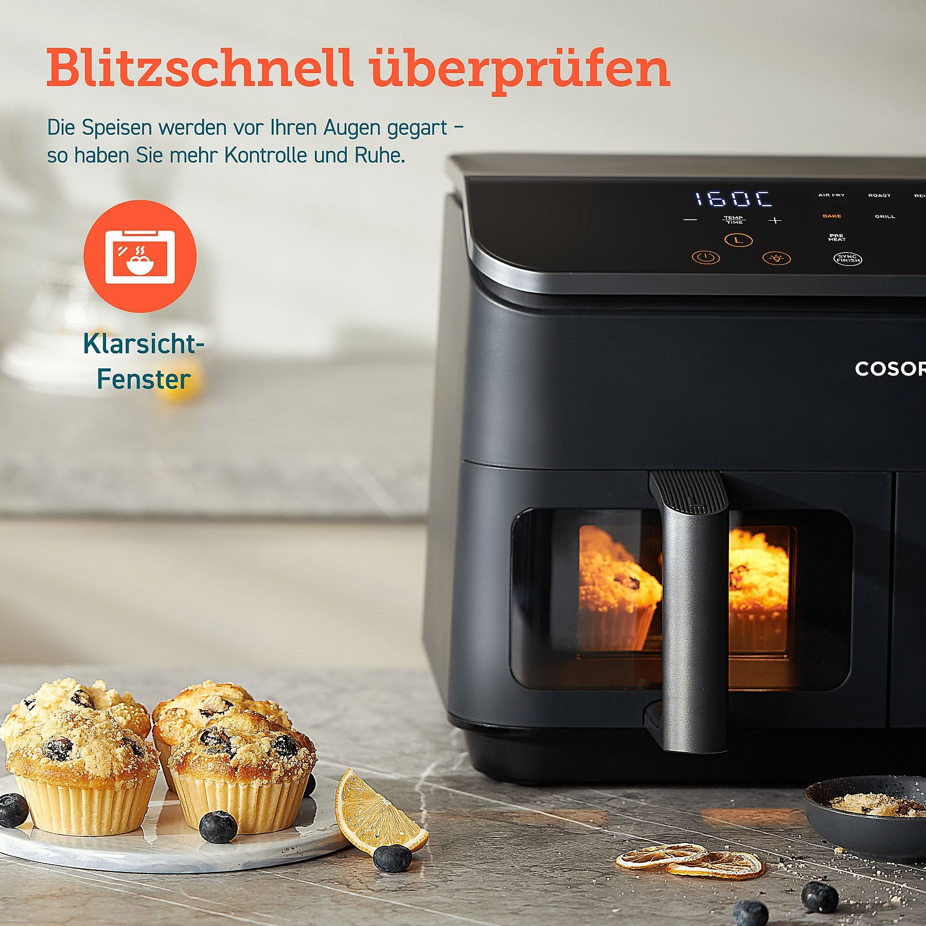 Friggitrice ad aria Cosori nera con finestra, accanto a muffin ai mirtilli.
