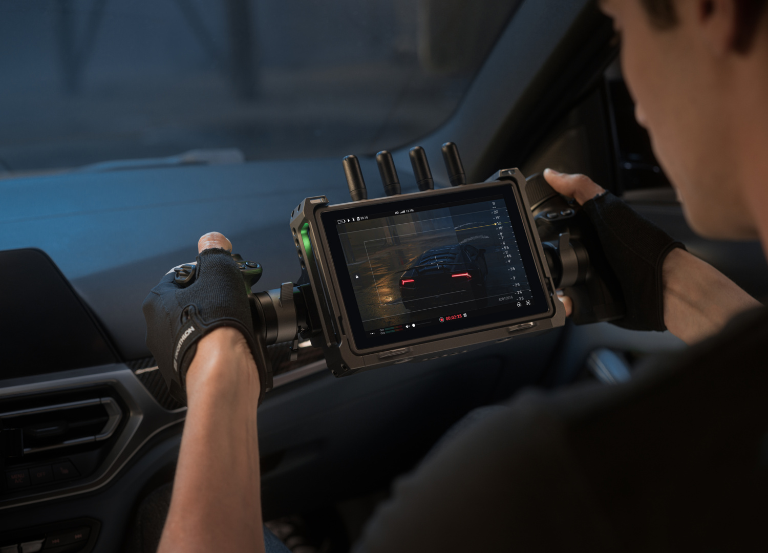 Personne en voiture tient écran montrant tableau de bord et données télémétrie.