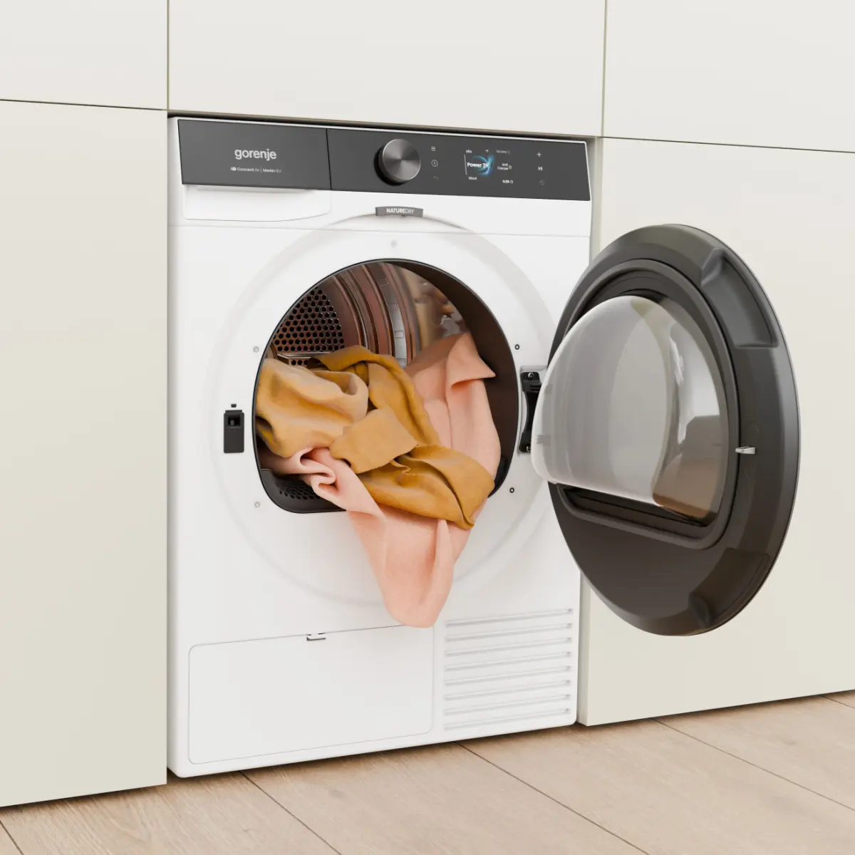 Egy fehér Gorenje mosógép nyitott ajtóval, benne ruhákkal.