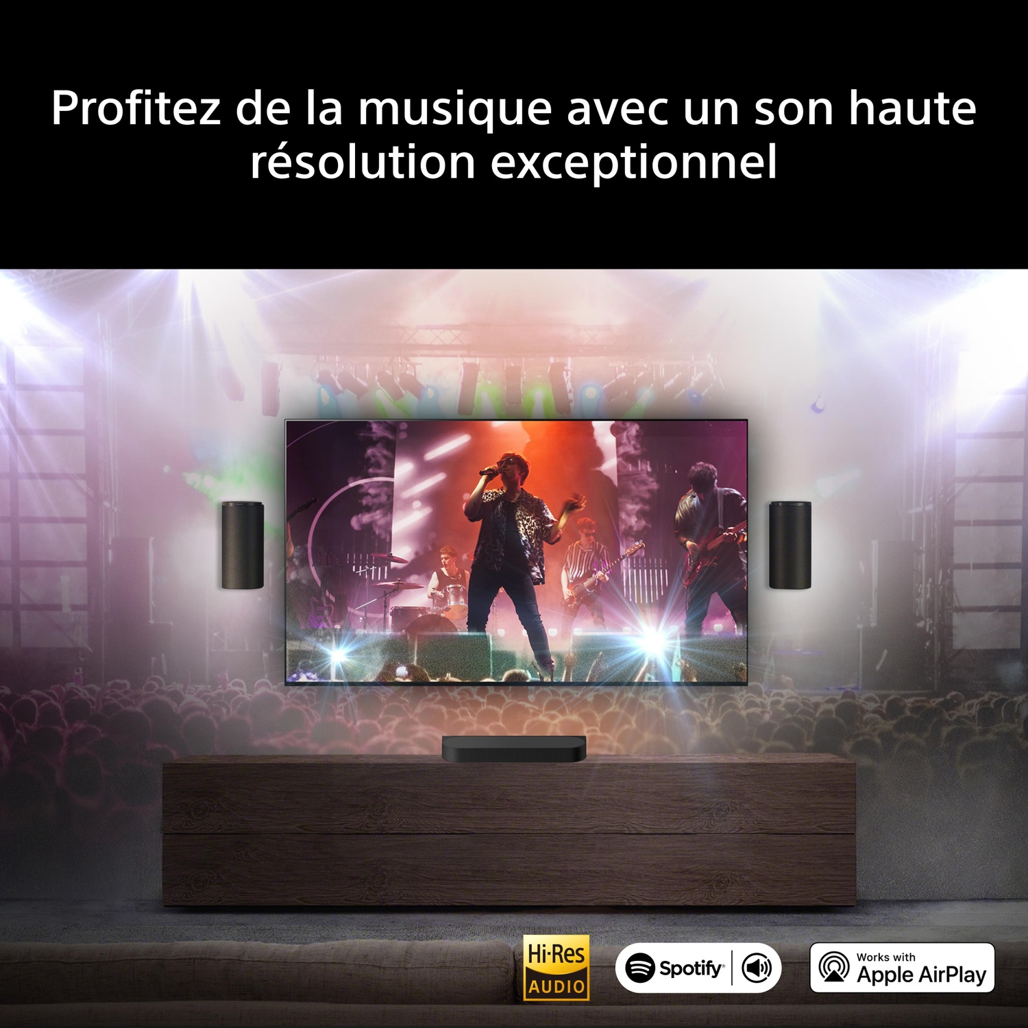 Een concert op tv, met speakers en soundbar, boven een meubel.