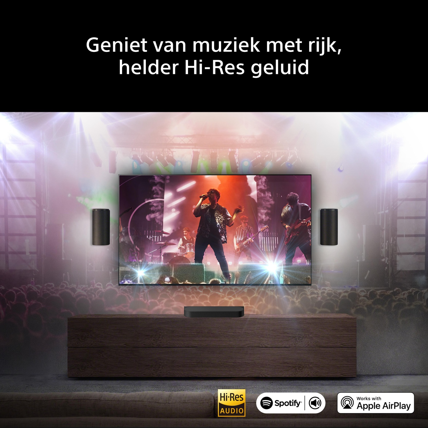 Een tv toont een concert. Links en rechts staan luidsprekers opgesteld.
