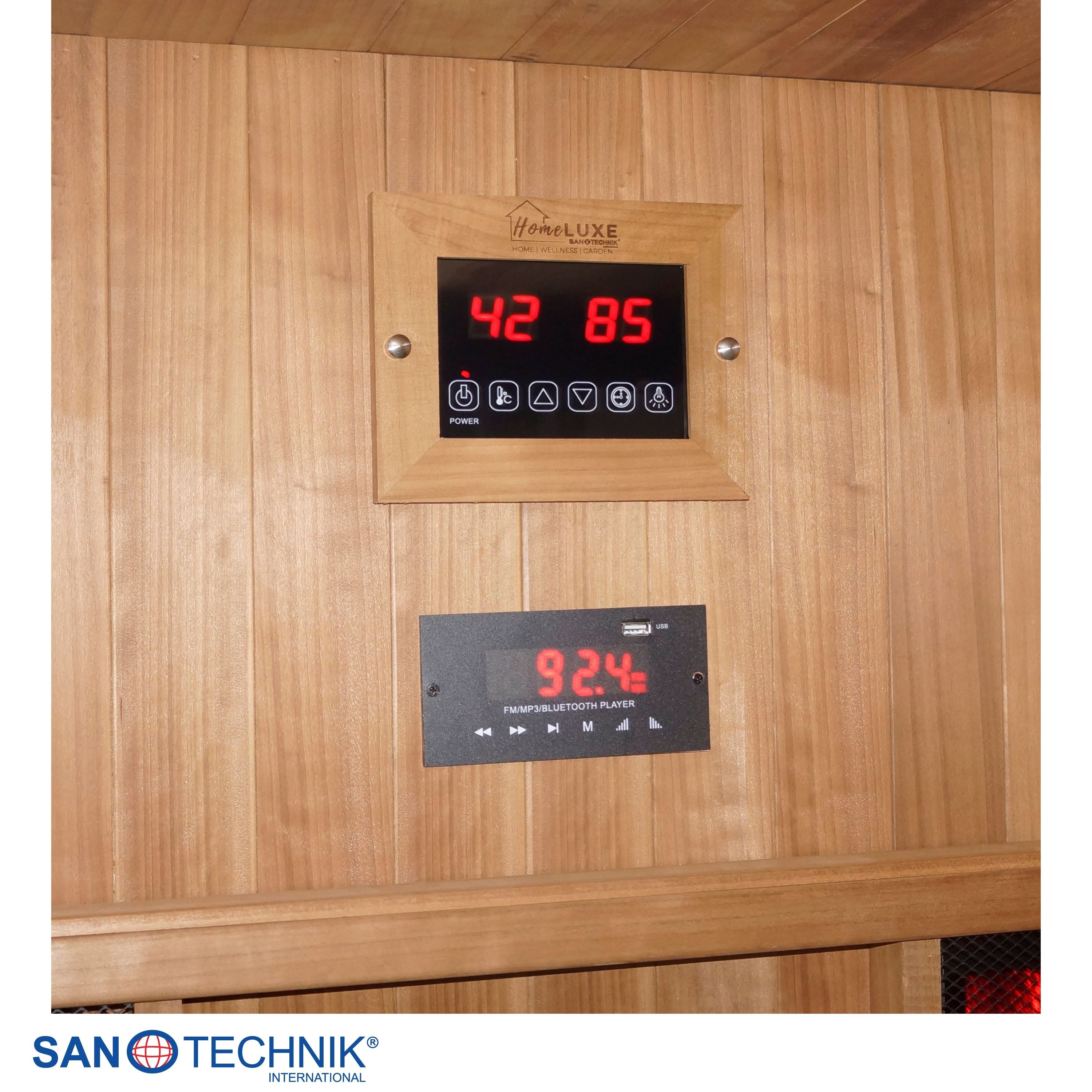 Holzverkleidete Sauna mit digitalen Steuerungen für Temperatur und Musik.