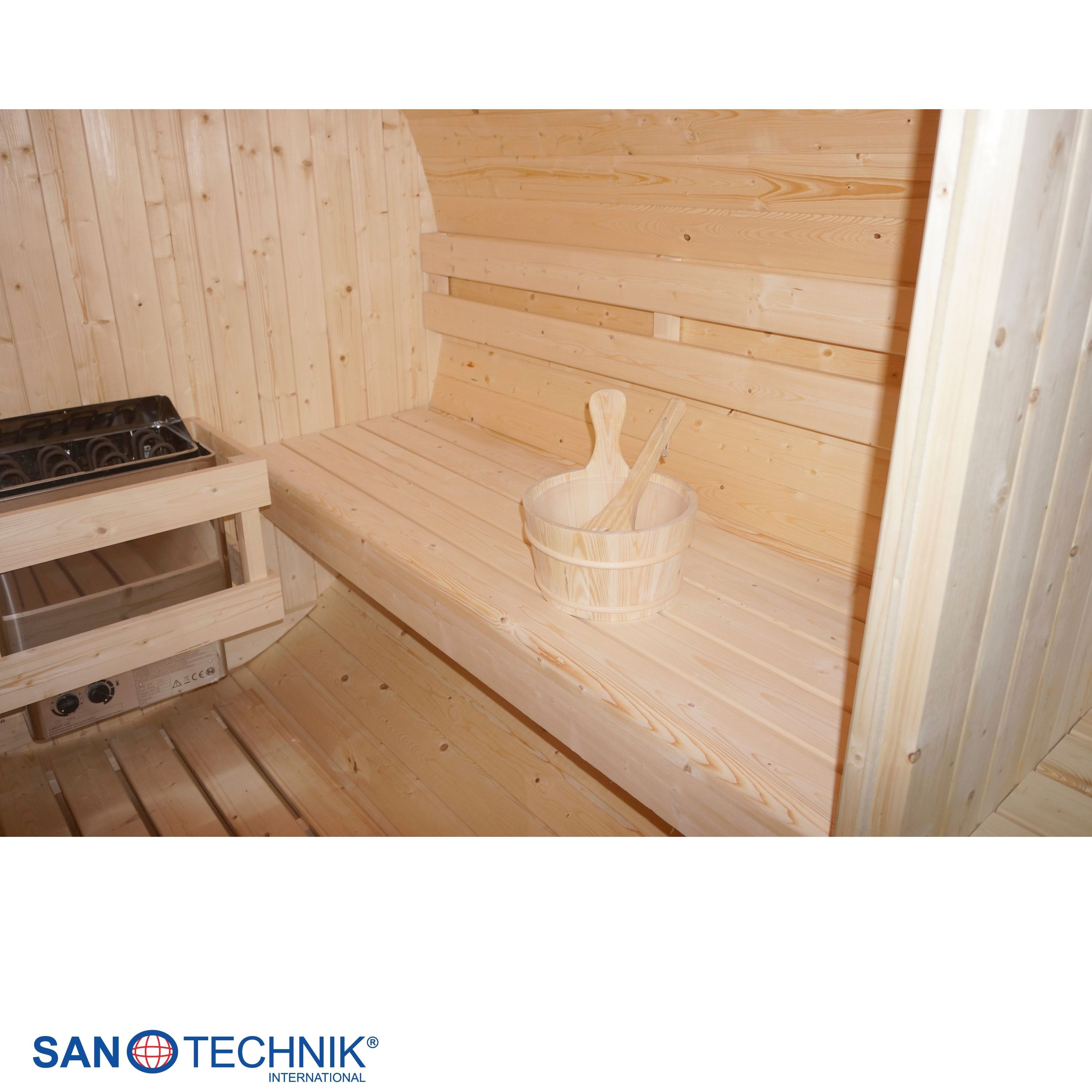 Innenansicht einer Holzhüttensauna mit Holzbänken, einem Eimer und einem Heizgerät.