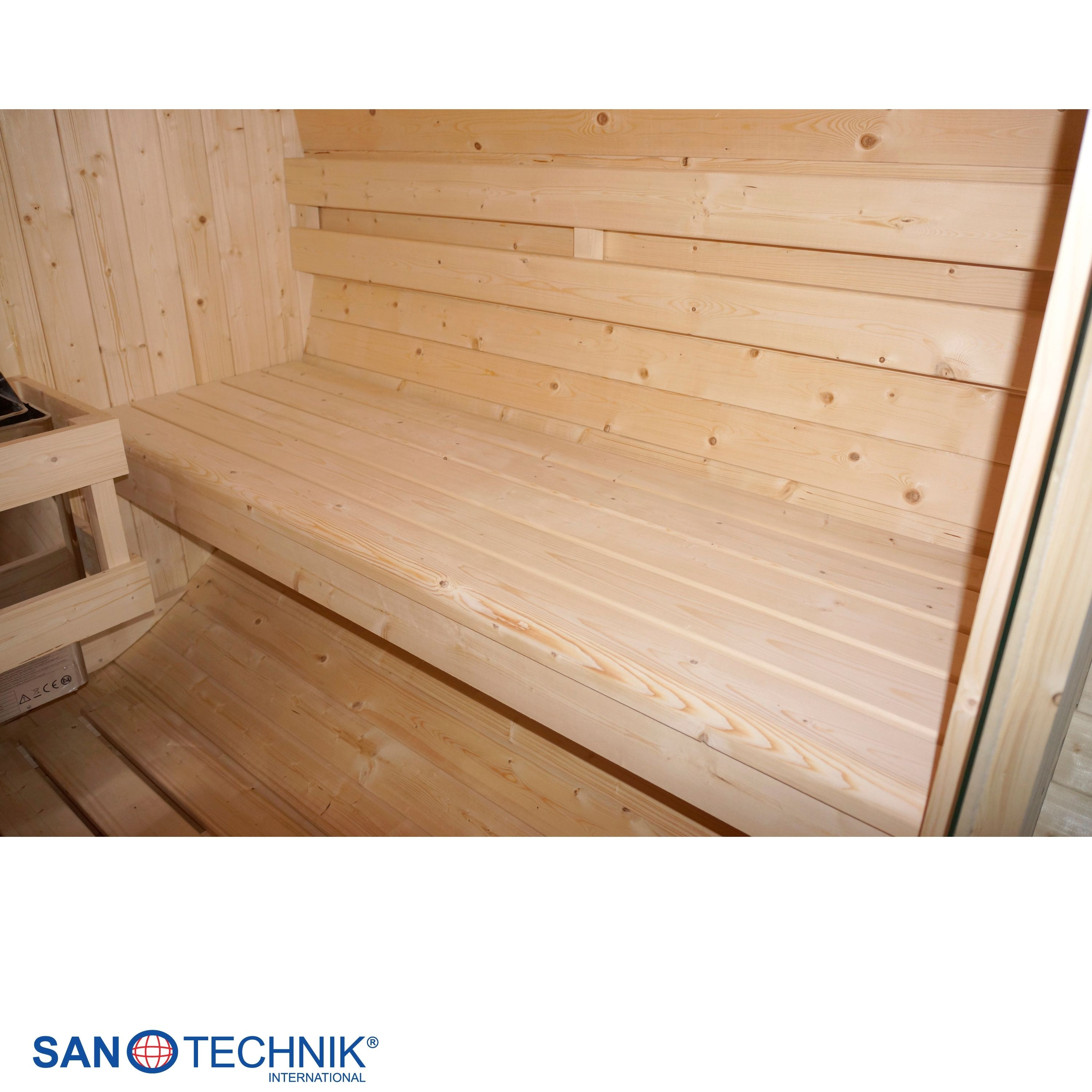 Innenansicht einer Holzhütte mit Holzbänken und einer Heizungseinheit.