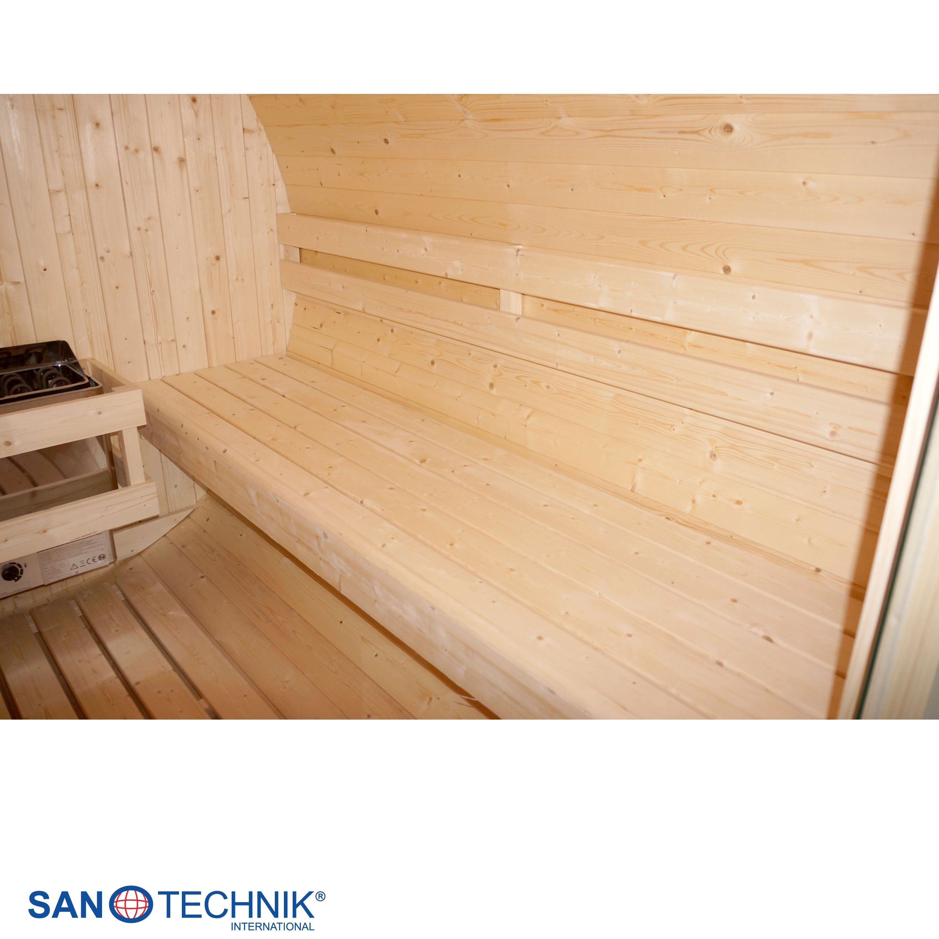 Innenansicht einer Holzsauna mit Bänken und einem Ofen.