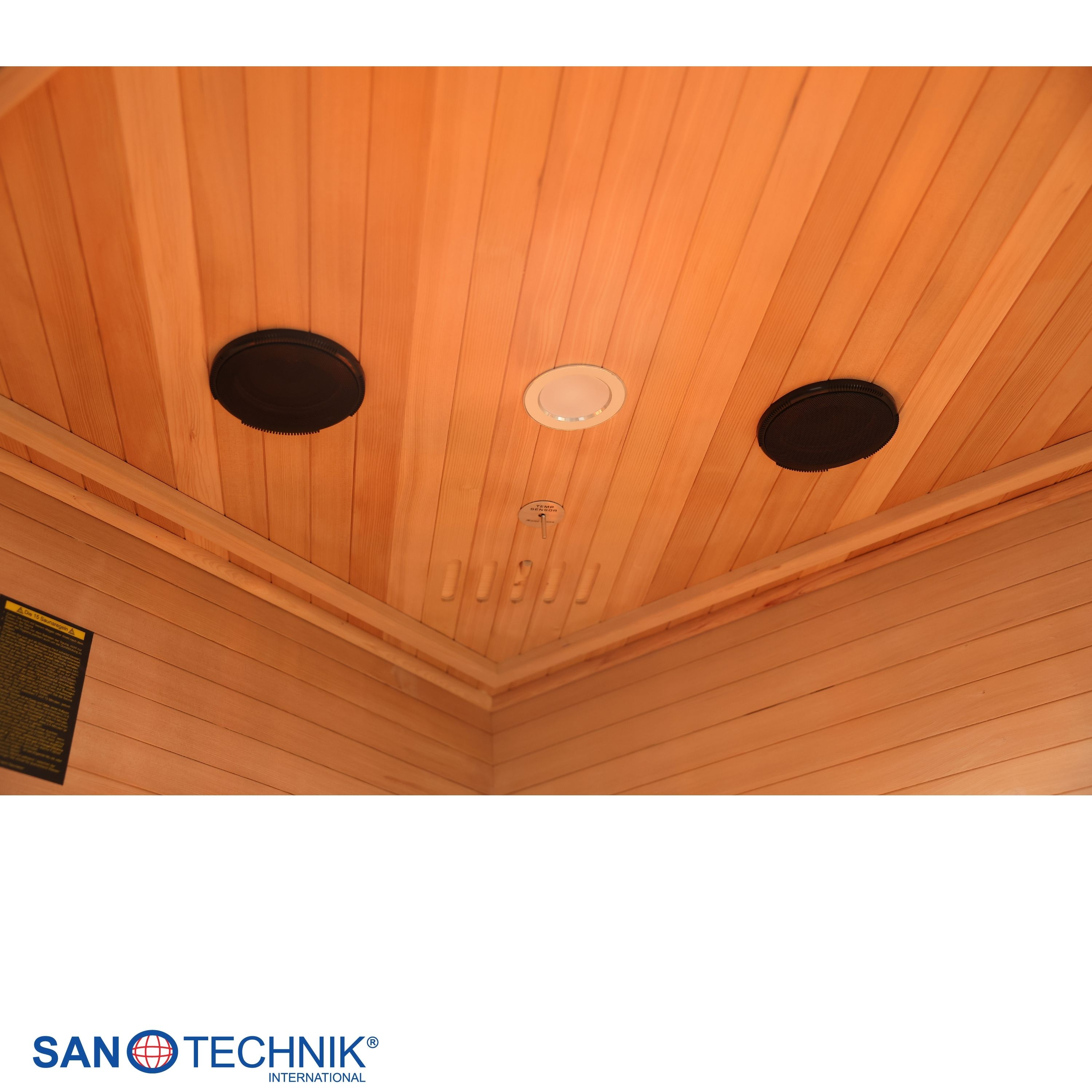 Holzdecke einer Sauna mit Lautsprechern, Licht und Lüftungsschlitzen.