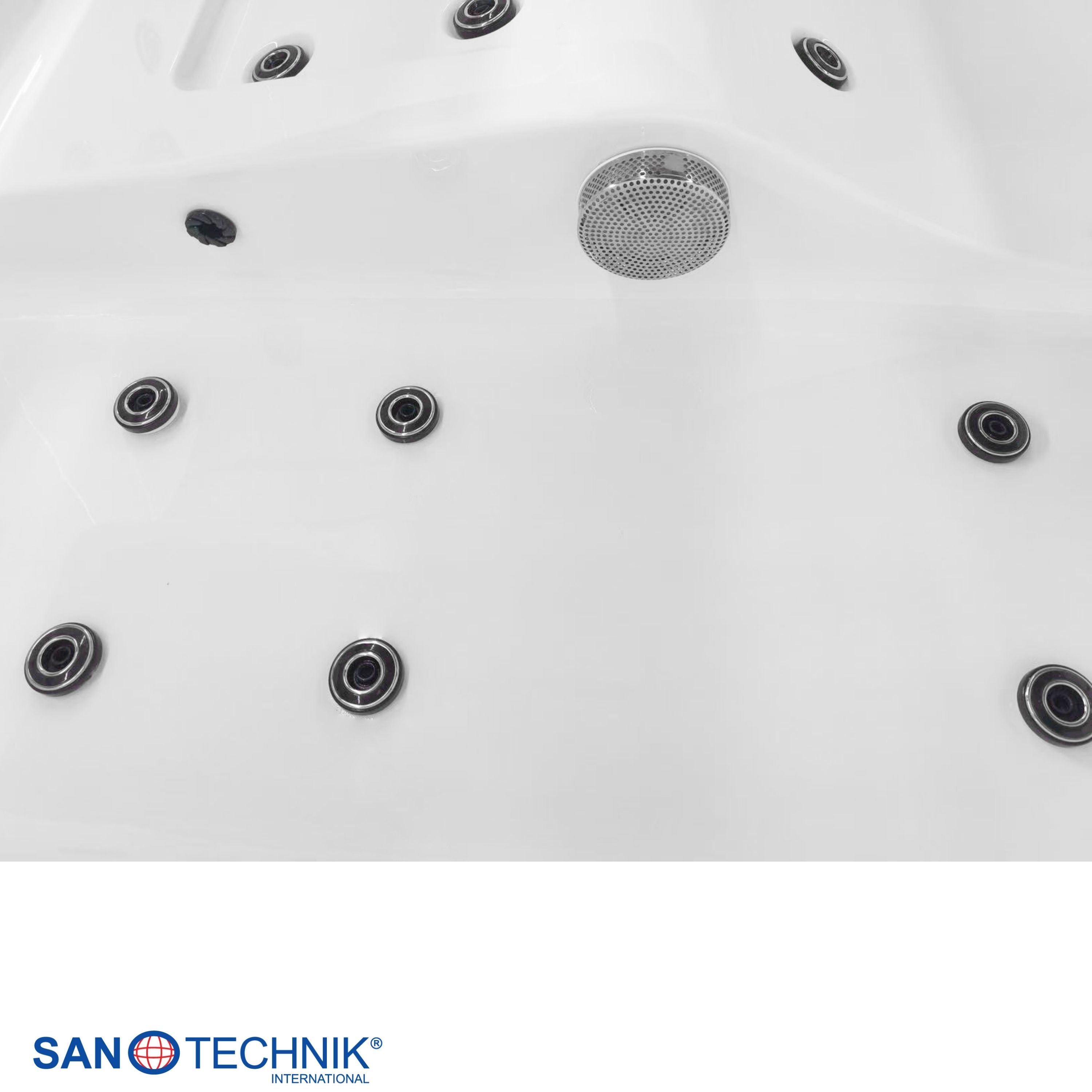 Nahaufnahme einer weißen Whirlpoolwanne mit mehreren Düsen und einem Abflussgitter.