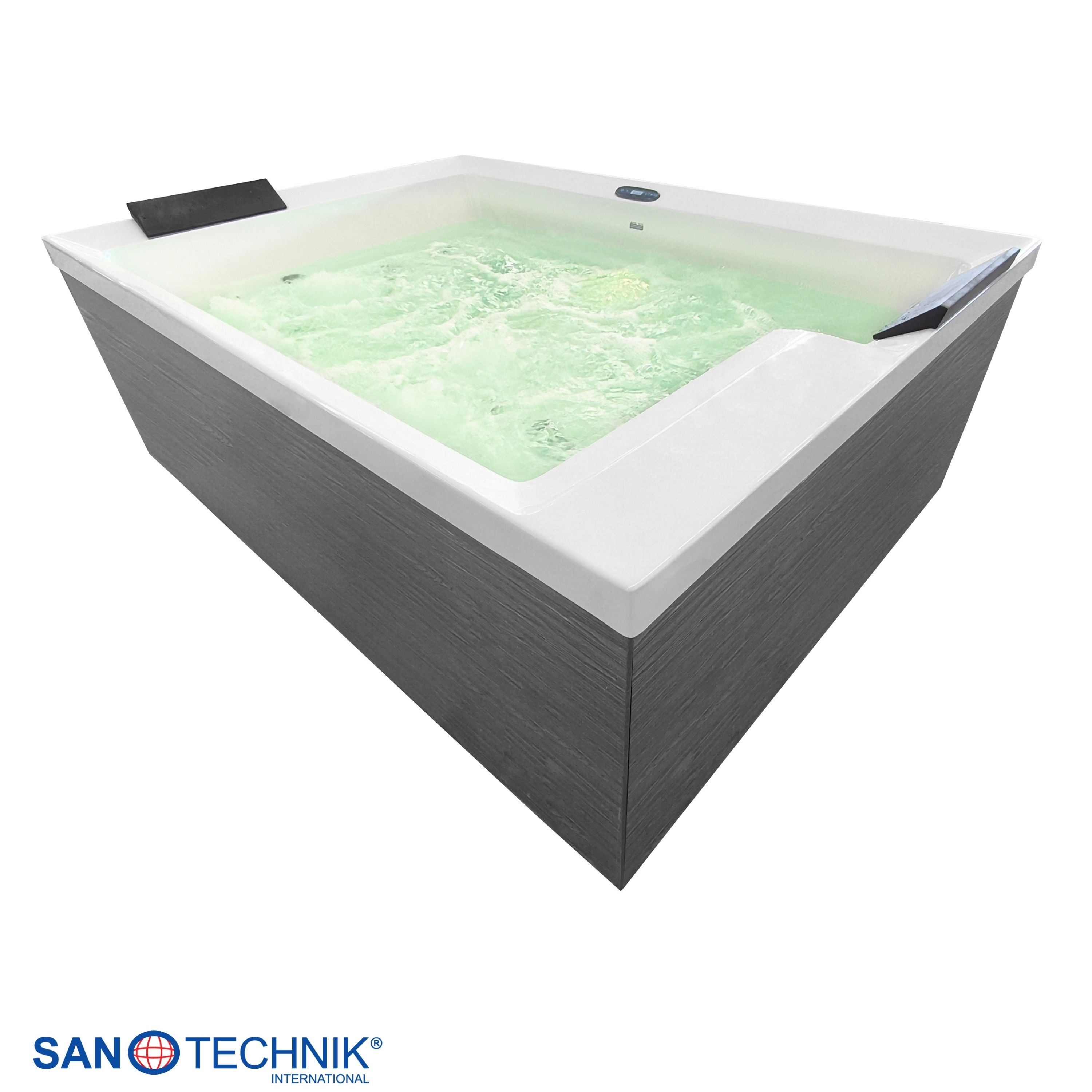 Ein moderner Whirlpool mit grauer Verkleidung und sprudelndem, hellgrünem Wasser.