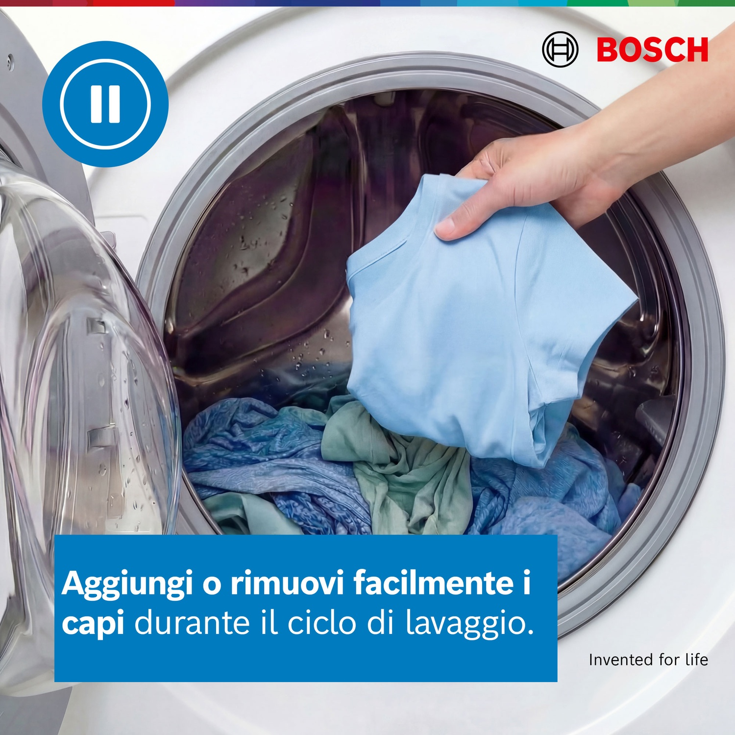 Una mano mette una maglietta azzurra in una lavatrice con panni.