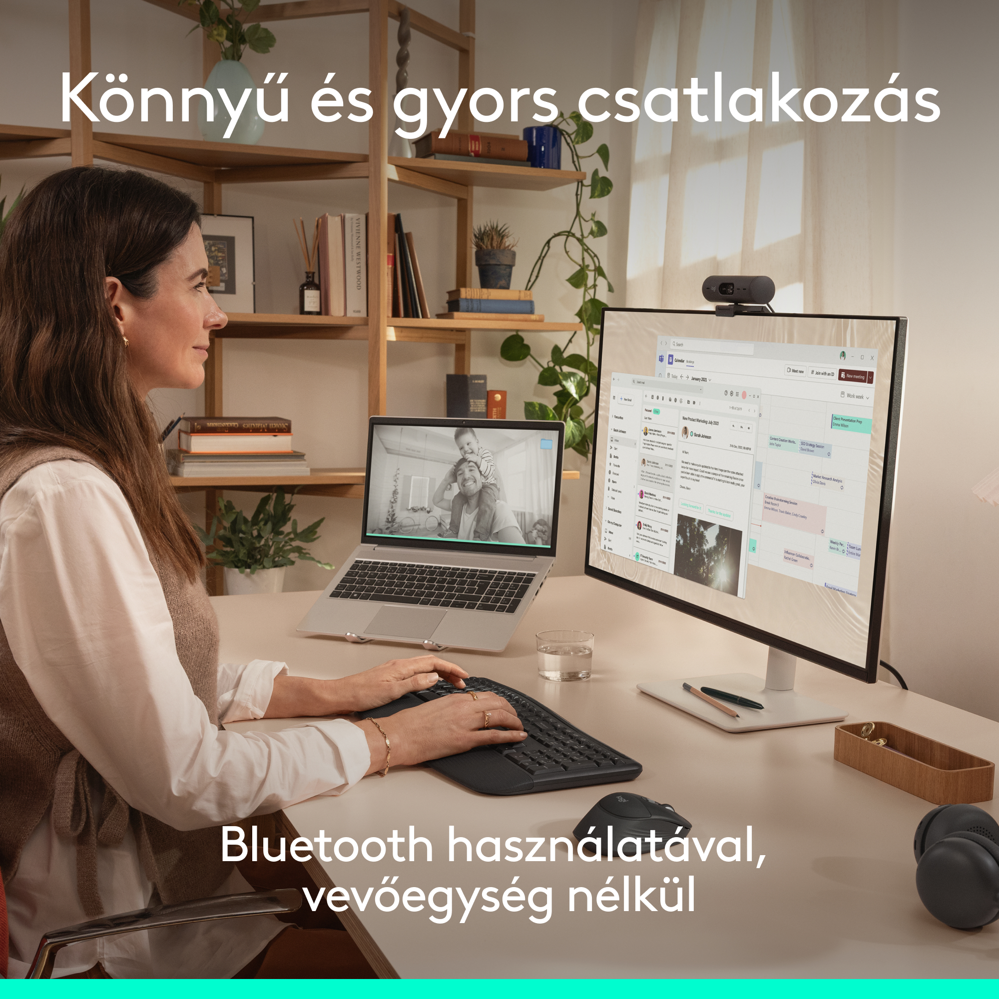 Nő az asztalnál laptop, monitor, webkamera. Billentyűzeten gépel. Könnyű csatlakozás.