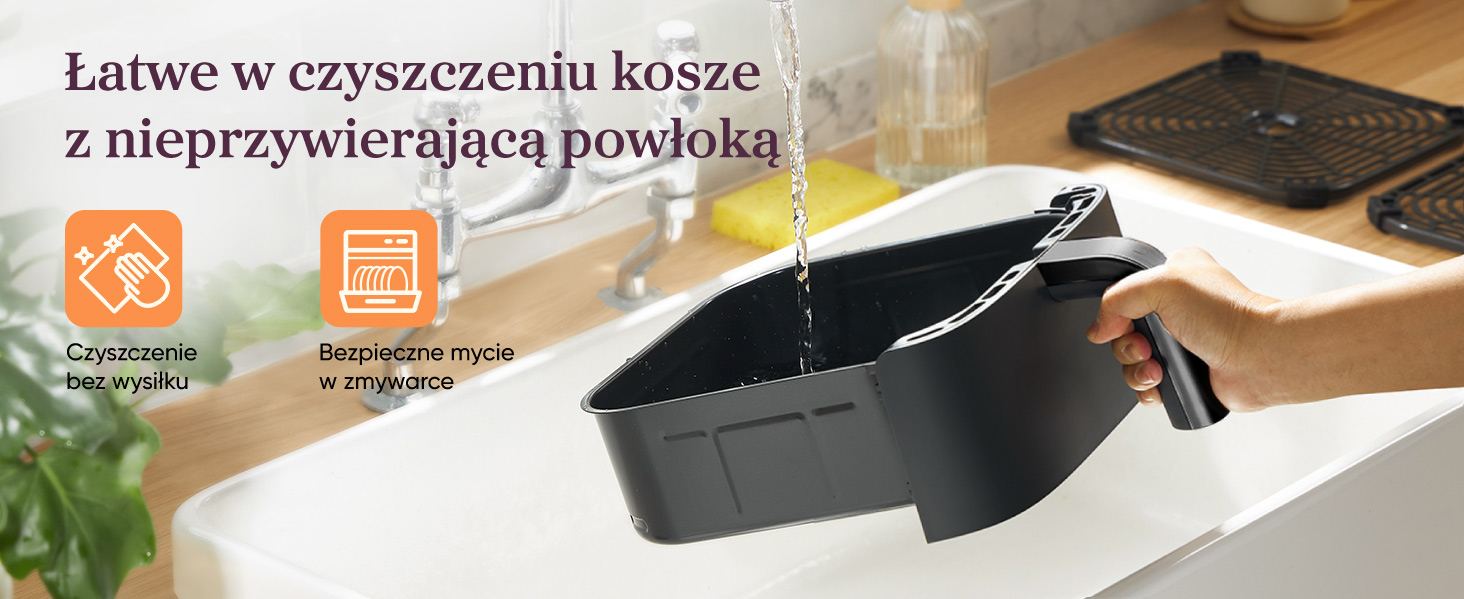 Ręka trzyma czarną wkładkę w zlewie pod bieżącą wodą.