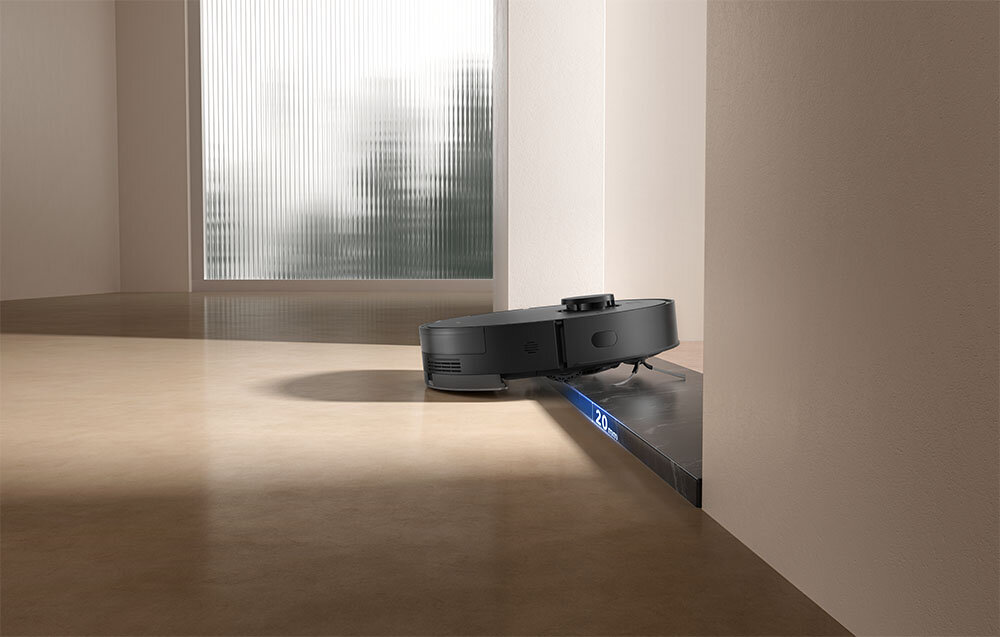 Czarny robot sprzątający porusza się po krawędzi oznaczonej "20 mm".