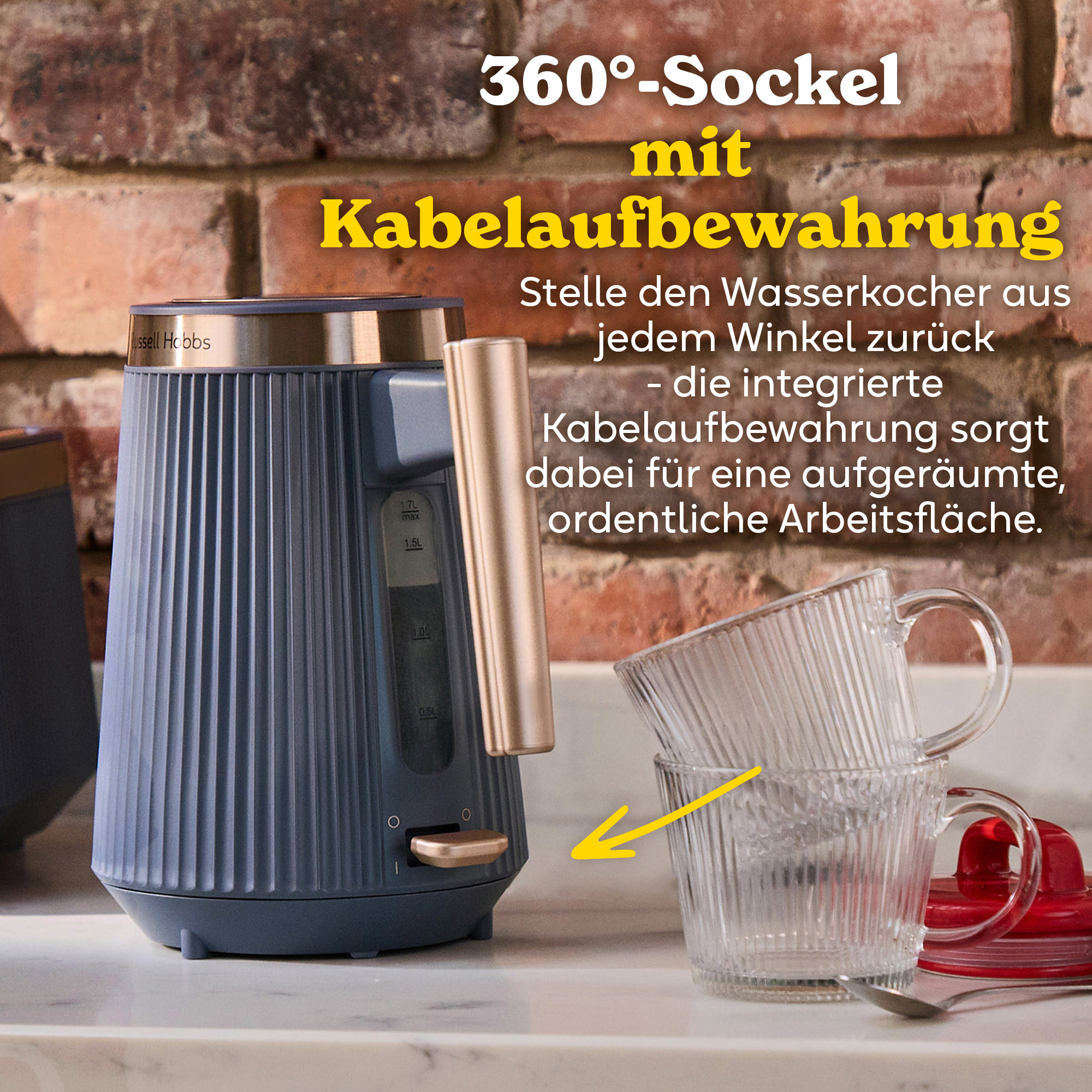 Ein blauer Russell Hobbs Wasserkocher mit goldenem Griff steht neben zwei Glasbechern.