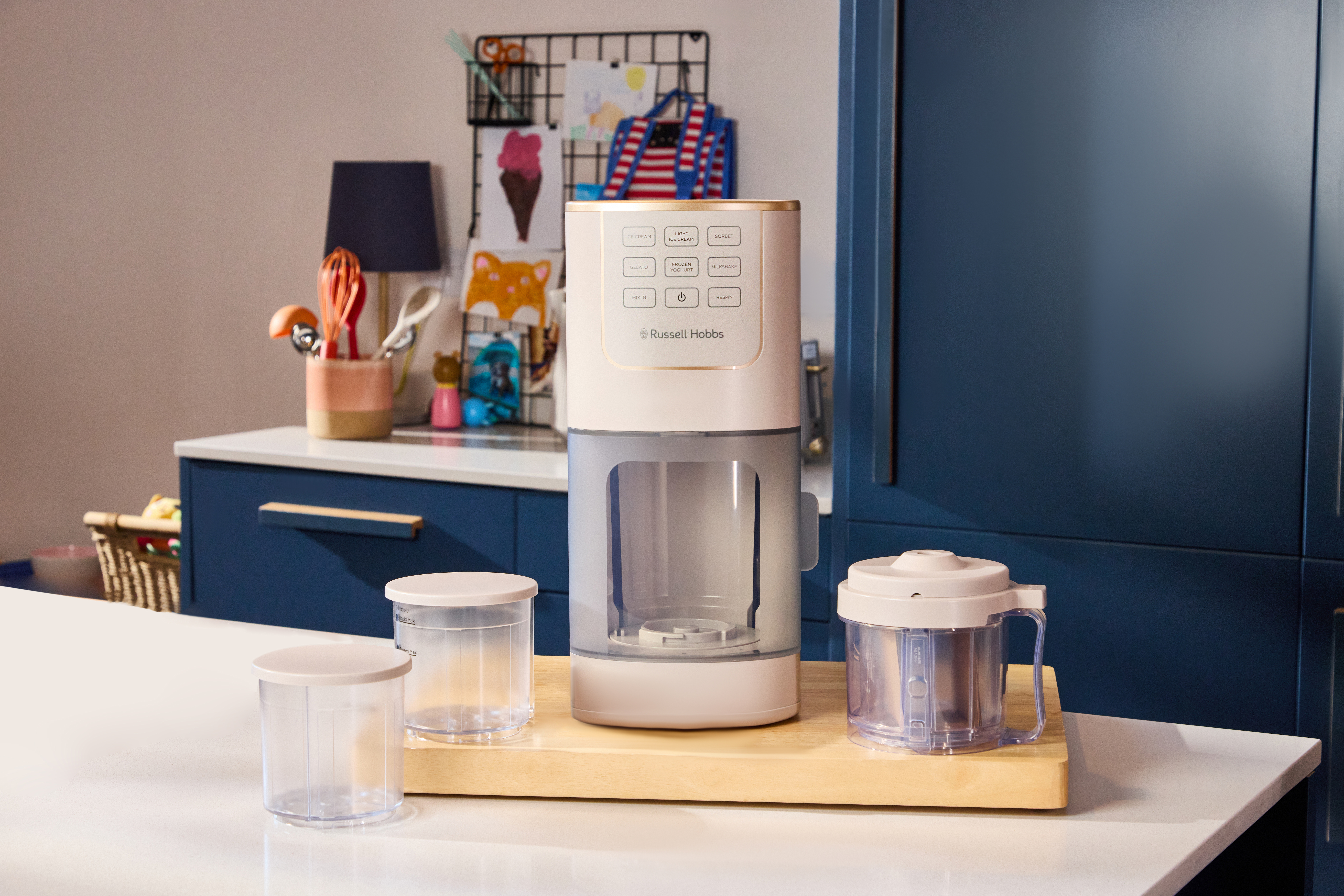 Ein Eisbereiter von Russell Hobbs steht auf einer Arbeitsplatte neben zwei Behältern.