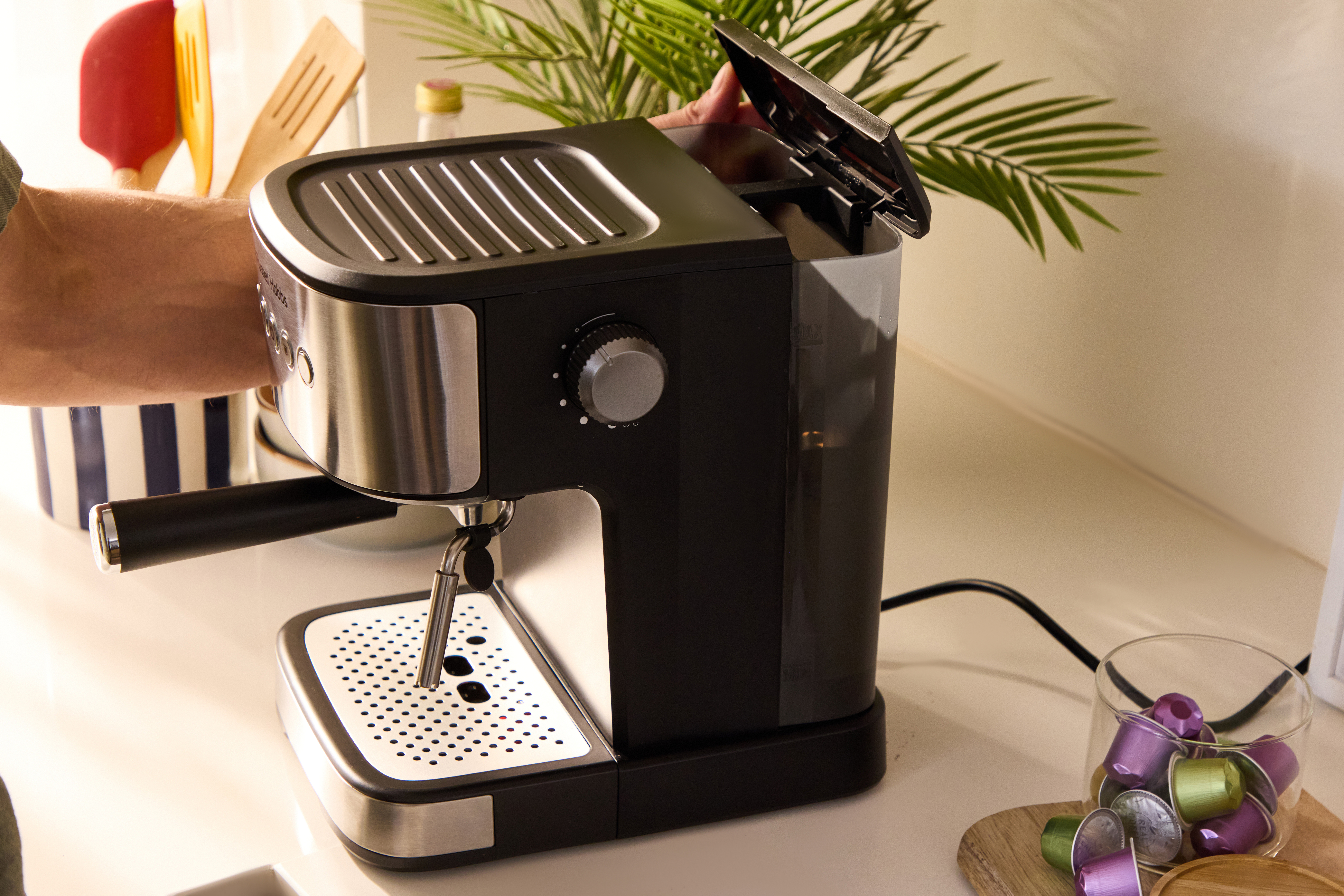 Eine schwarze Espressomaschine mit Chromdetails auf einer Arbeitsplatte.