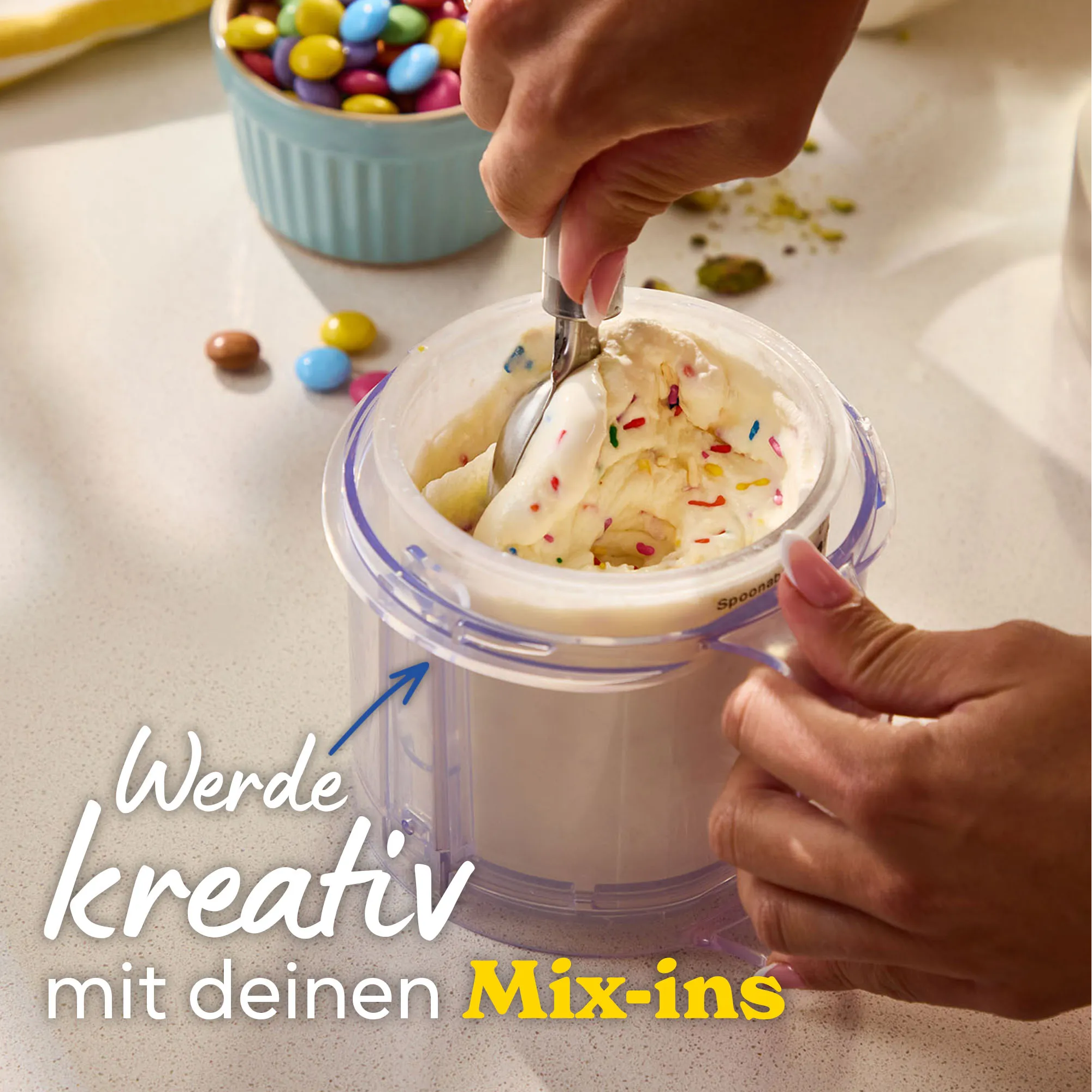 Hände fügen Streusel zu Eiscreme in einer Maschine hinzu.