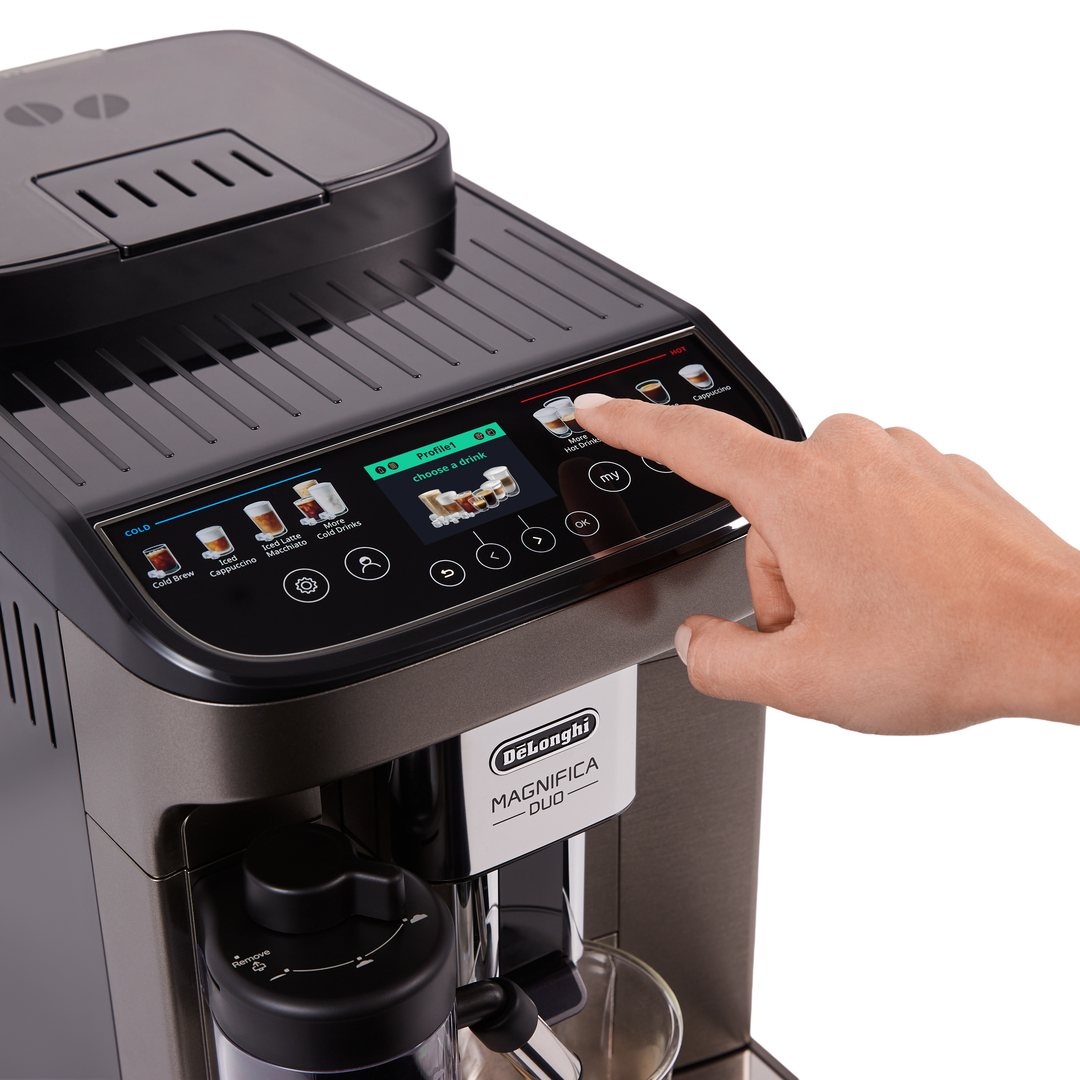 Una mano tocca lo schermo di una macchina da caffè per selezionare una bevanda.