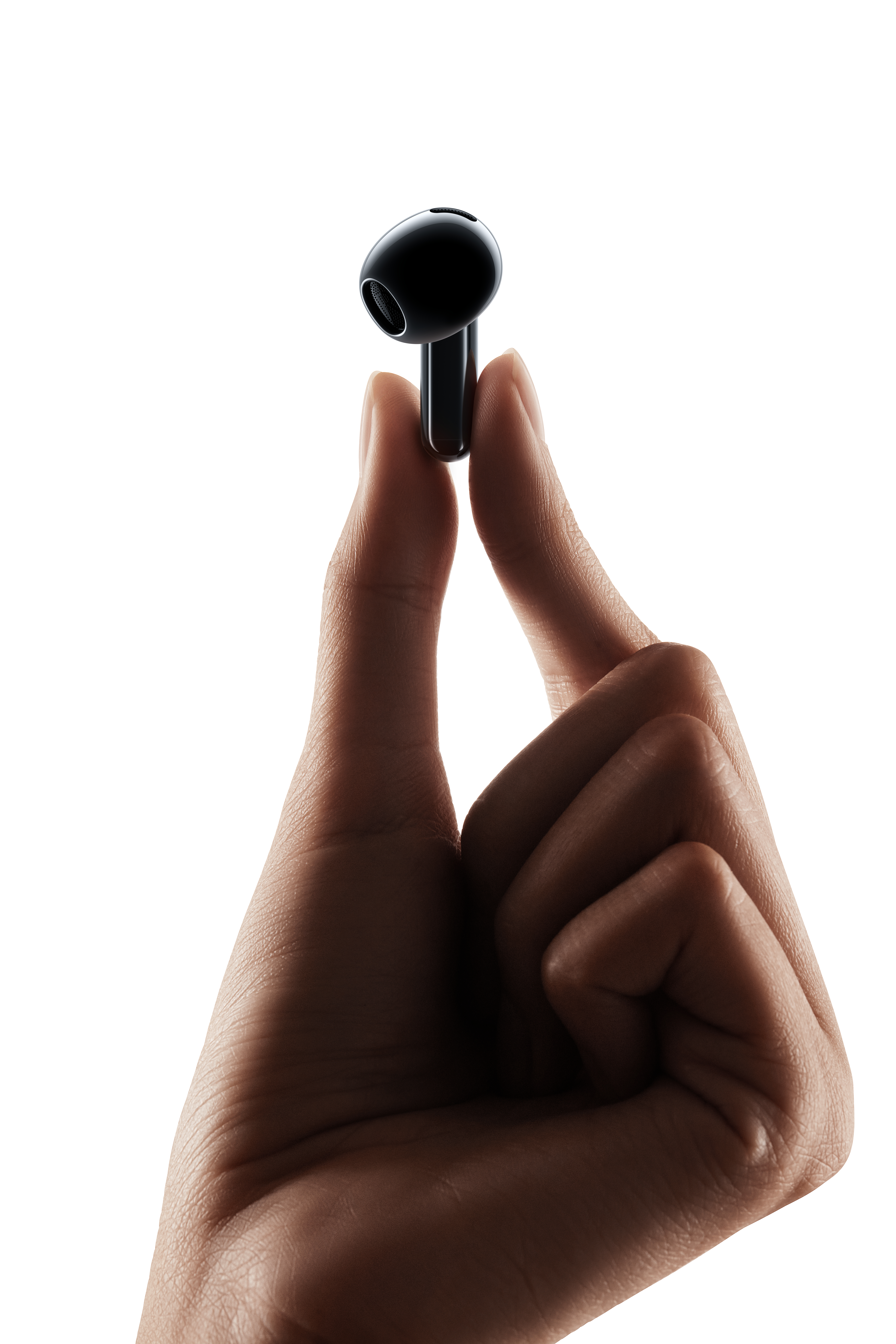 Eine Hand hält einen einzelnen schwarzen Ohrhörer zwischen Daumen und Zeigefinger.