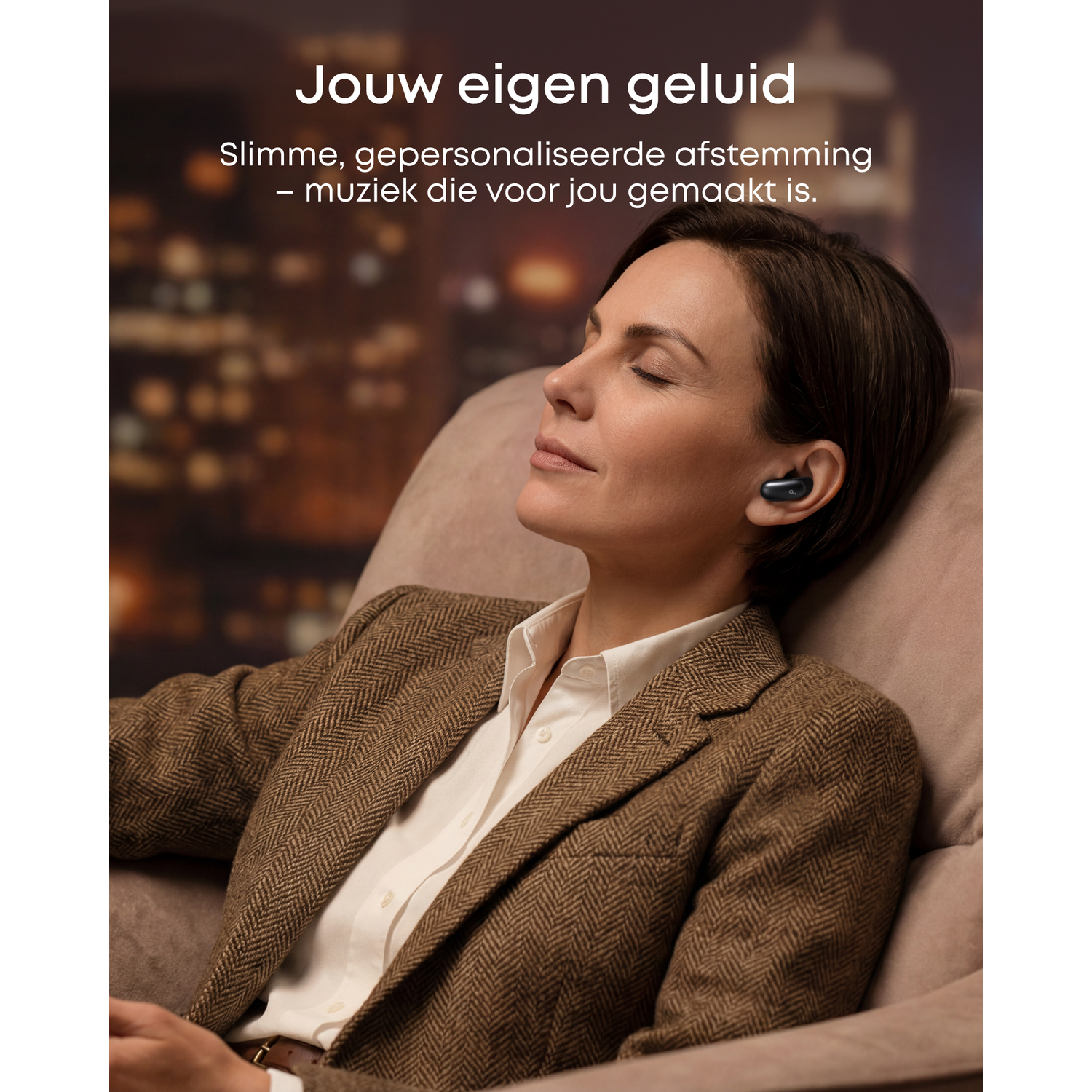 Een vrouw met gesloten ogen zit in een fauteuil en draagt oordopjes.
