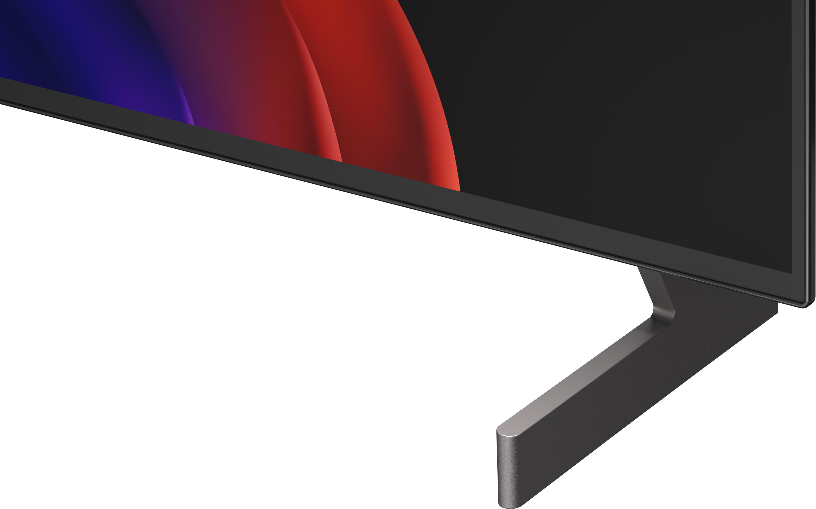 Ein schwarzer Fernseher mit einem grauen Standfuß vor einem weißen Hintergrund.