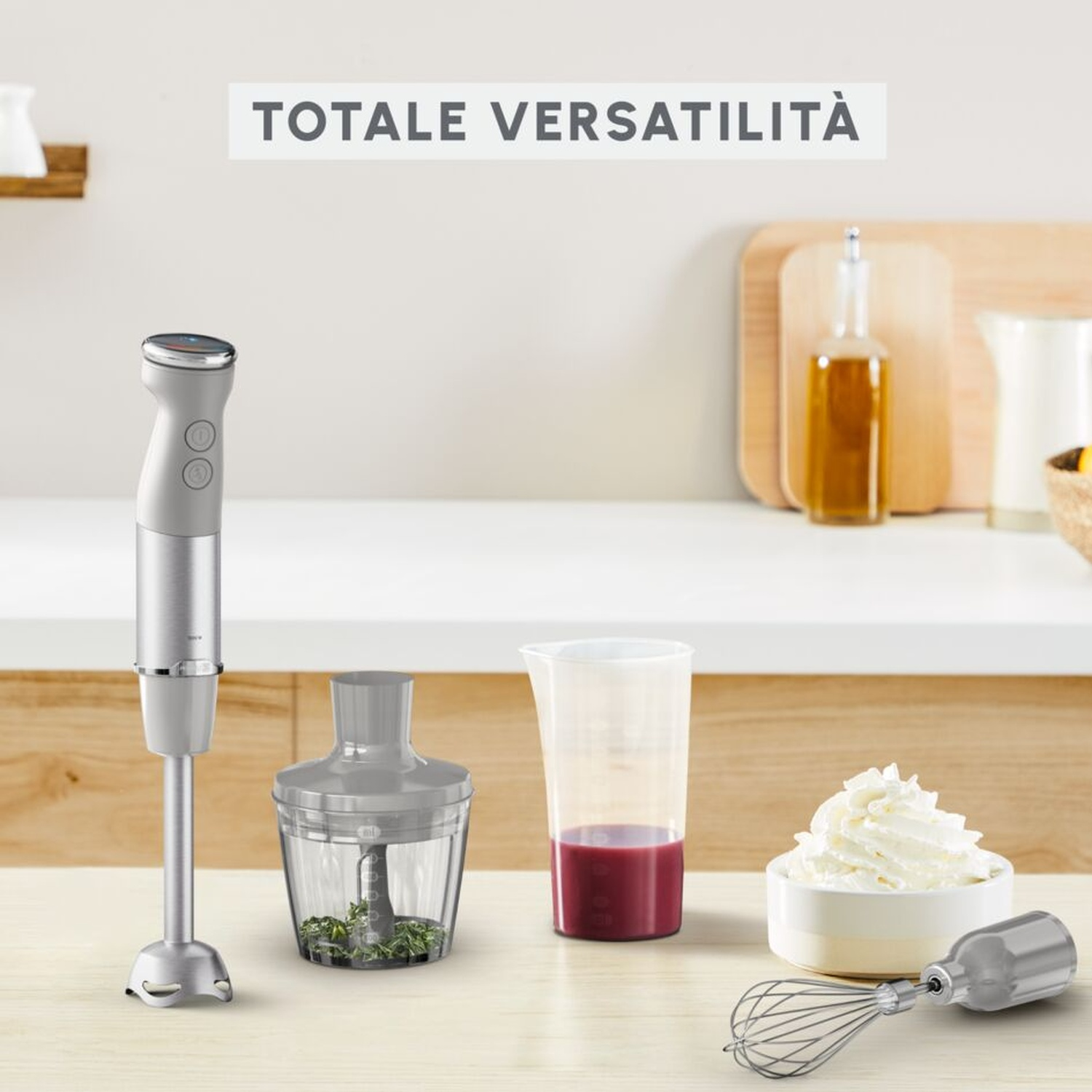 Un frullatore a immersione con accessori: tritacarne, misurino, frusta e panna montata.
