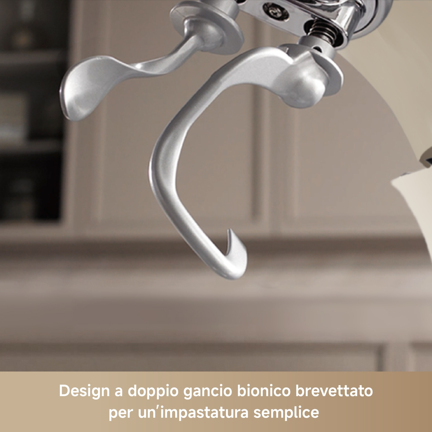 Primo piano di un gancio doppio argentato per impastatrice su sfondo cucina.