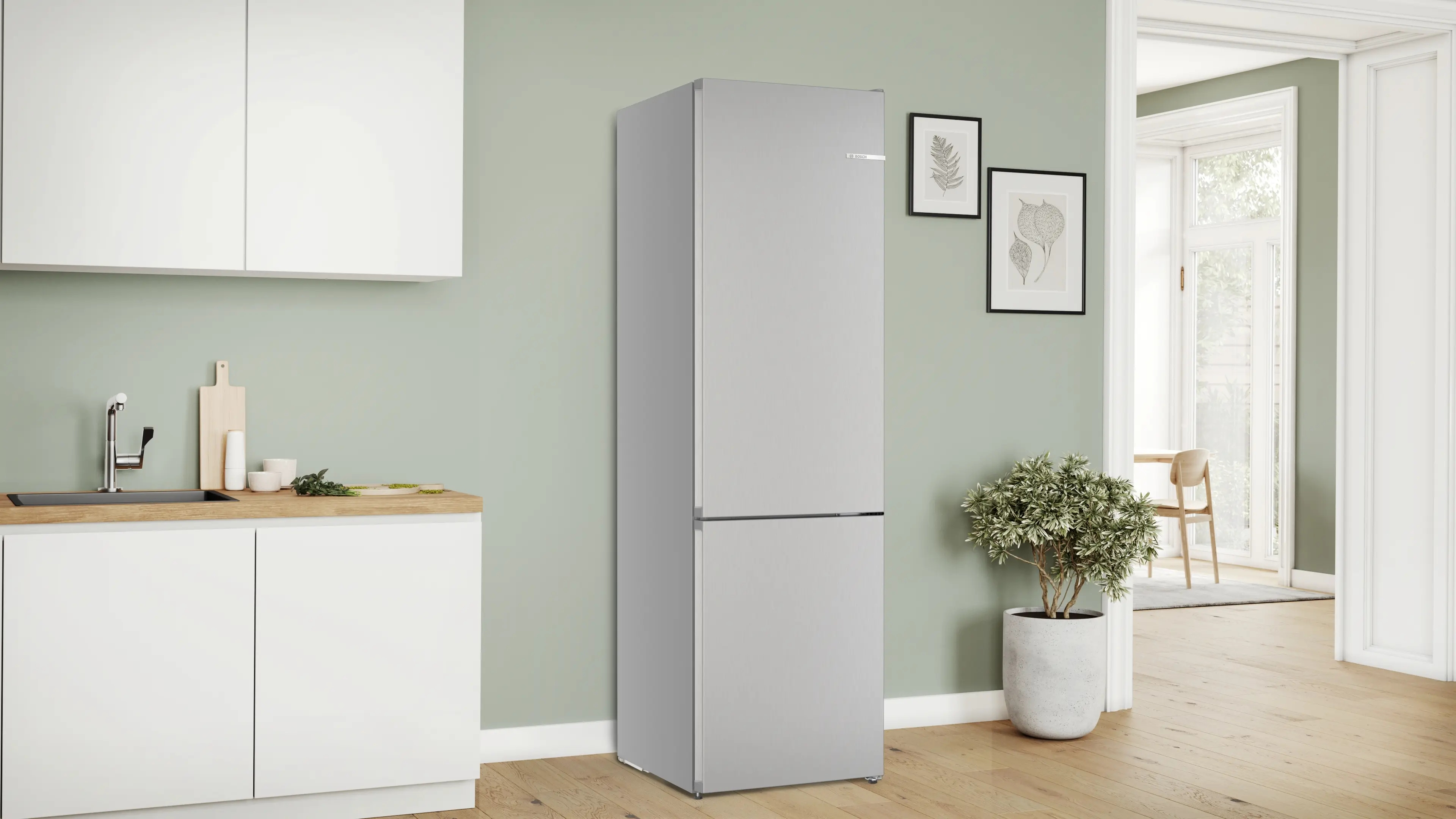 Un refrigerador plateado y delgado junto a una encimera de cocina con fregadero.