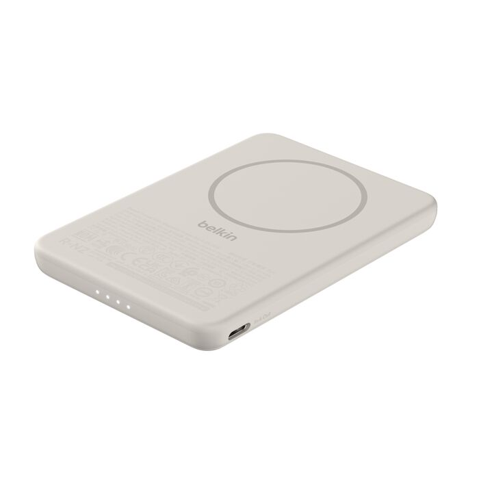 Un cargador portátil rectangular de color crema con una hendidura circular y el logo 'Belkin', con pequeñas luces indicadoras y un puerto en el lateral.