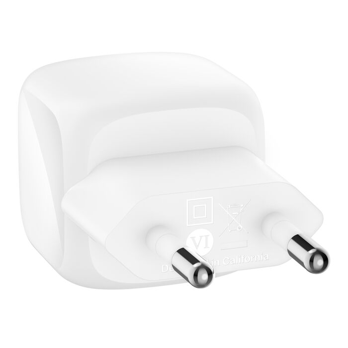 Un adaptador de corriente blanco con dos clavijas metálicas y el símbolo VI.