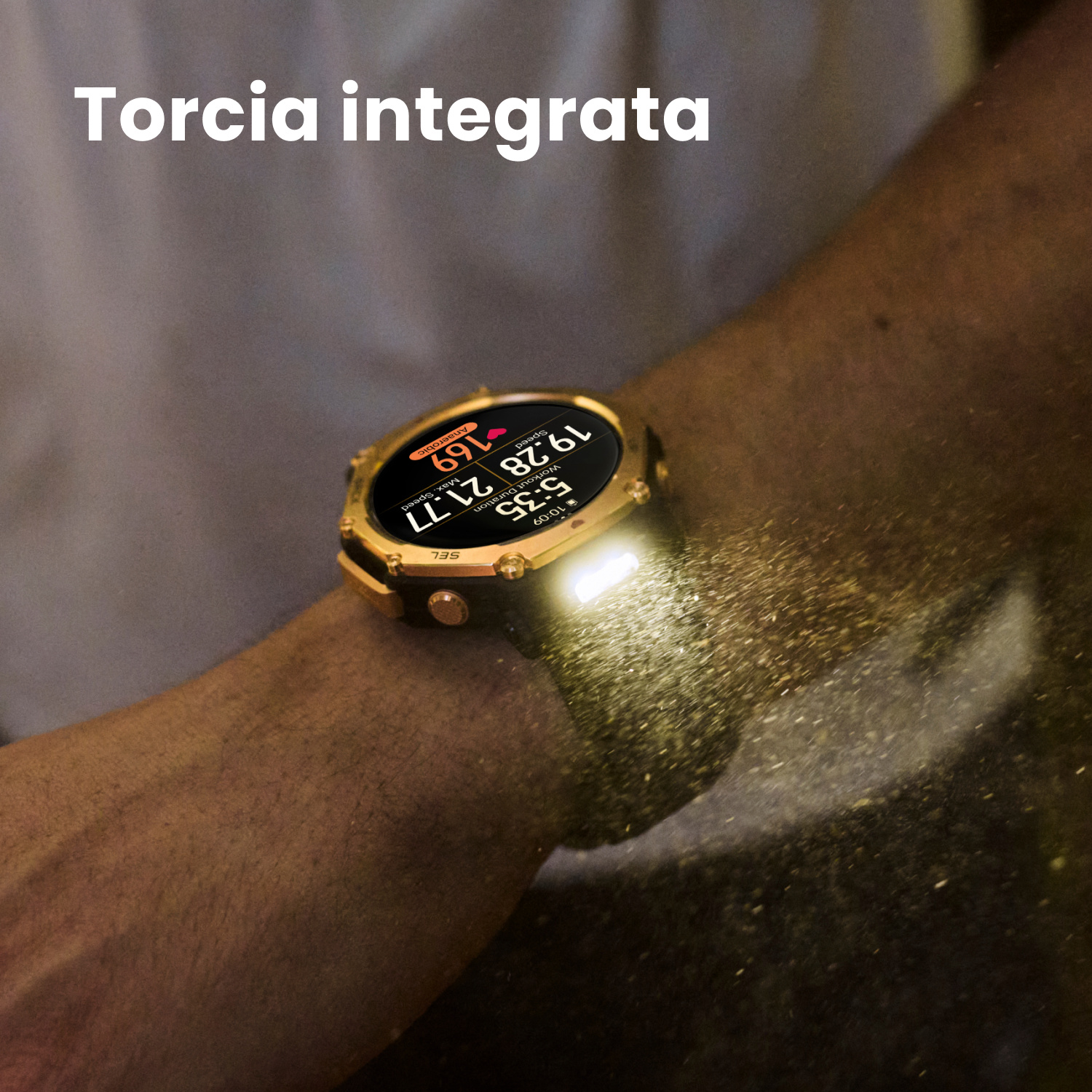 Uno smartwatch dorato con torcia illuminata su un braccio, particelle di polvere volanti.