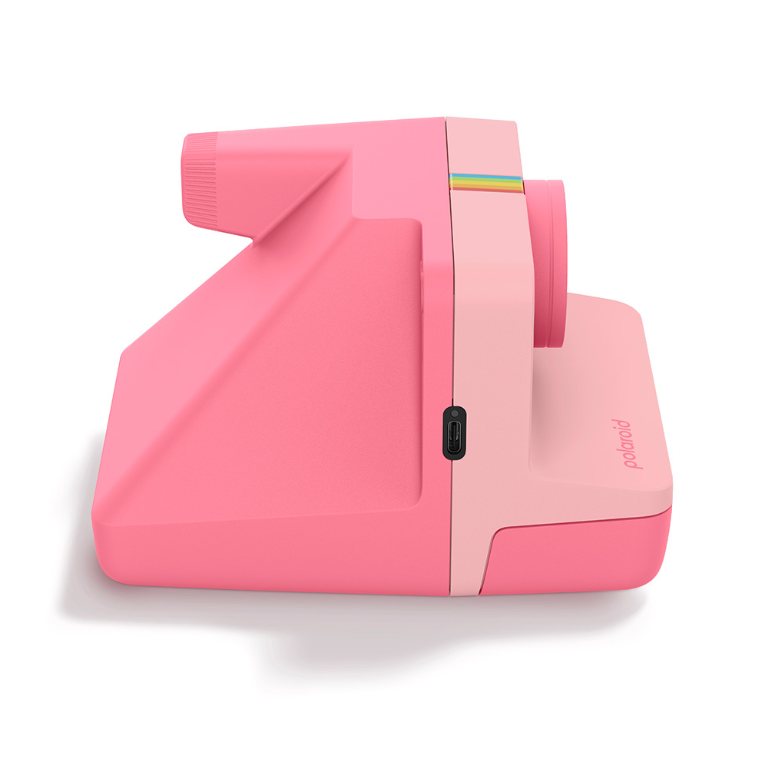 Eine pinke Polaroid-Kamera mit Regenbogen-Akzent und USB-Anschluss.