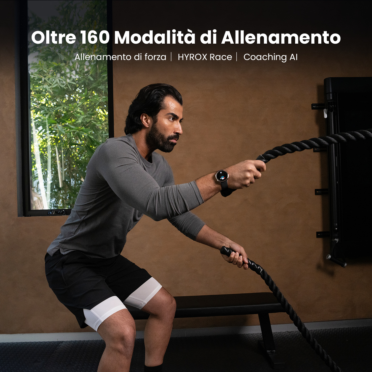 Un uomo si allena con una corda pesante in palestra. Indossa abbigliamento sportivo.
