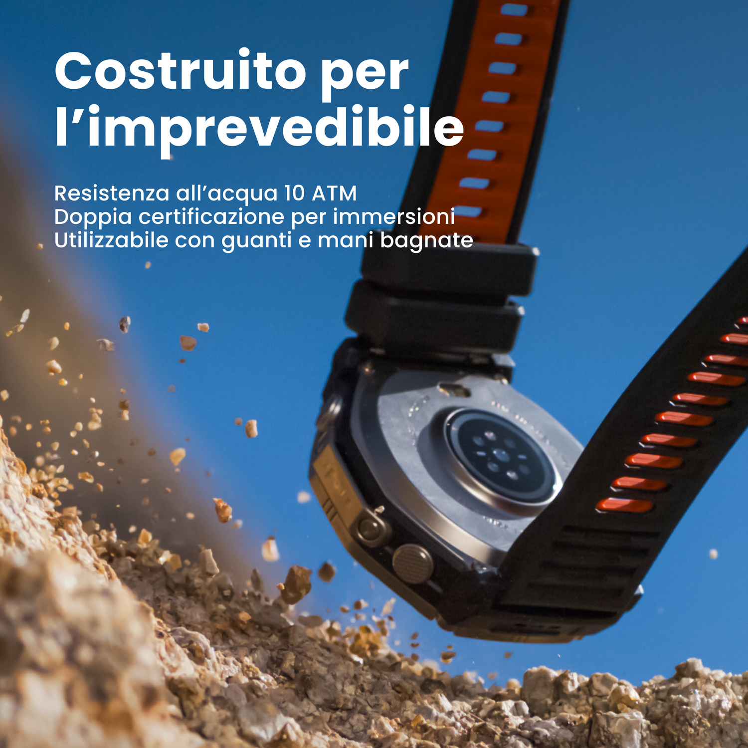Orologio con cinturino arancione su terreno roccioso, cielo blu.