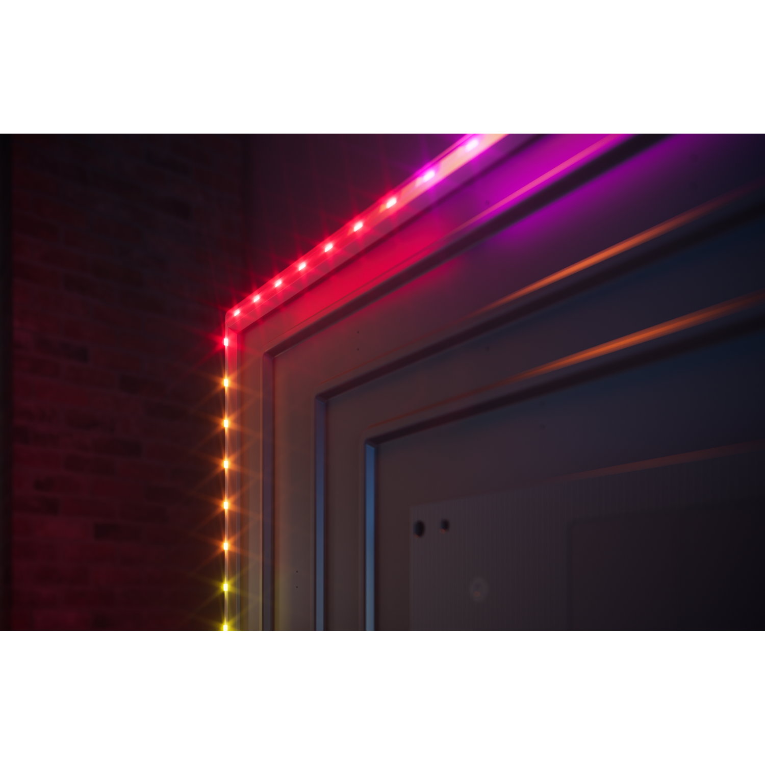 Een strook kleurrijke LED-verlichting verlicht een deuropening met rode, roze en gele tinten.